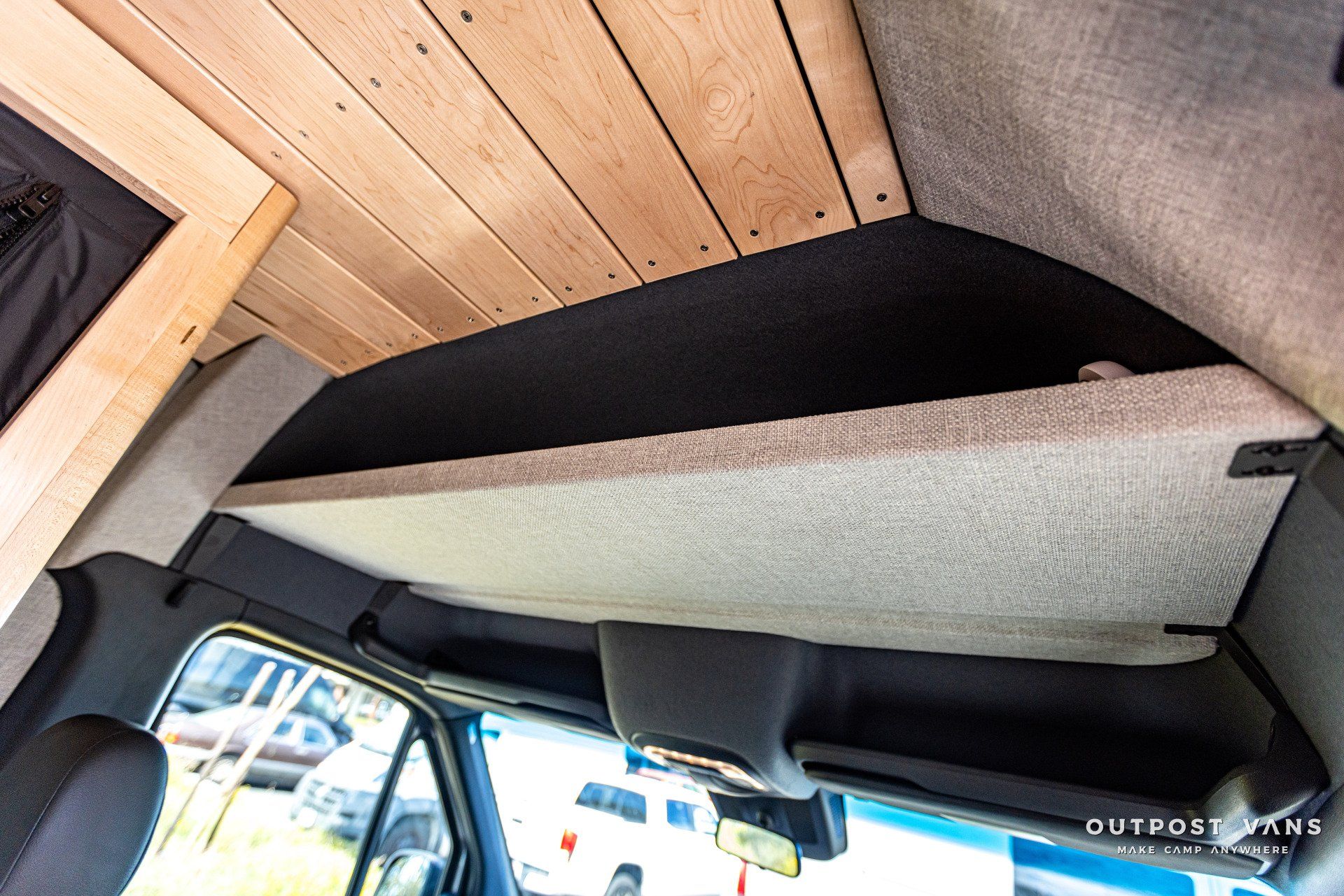 There is a bed in the ceiling of a van.