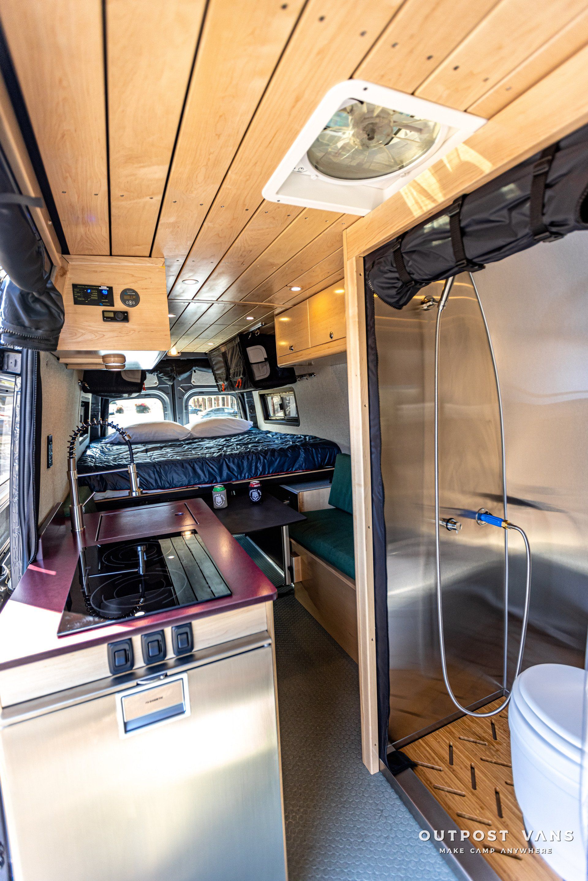 The inside of a camper van with a stove , sink , toilet and shower.