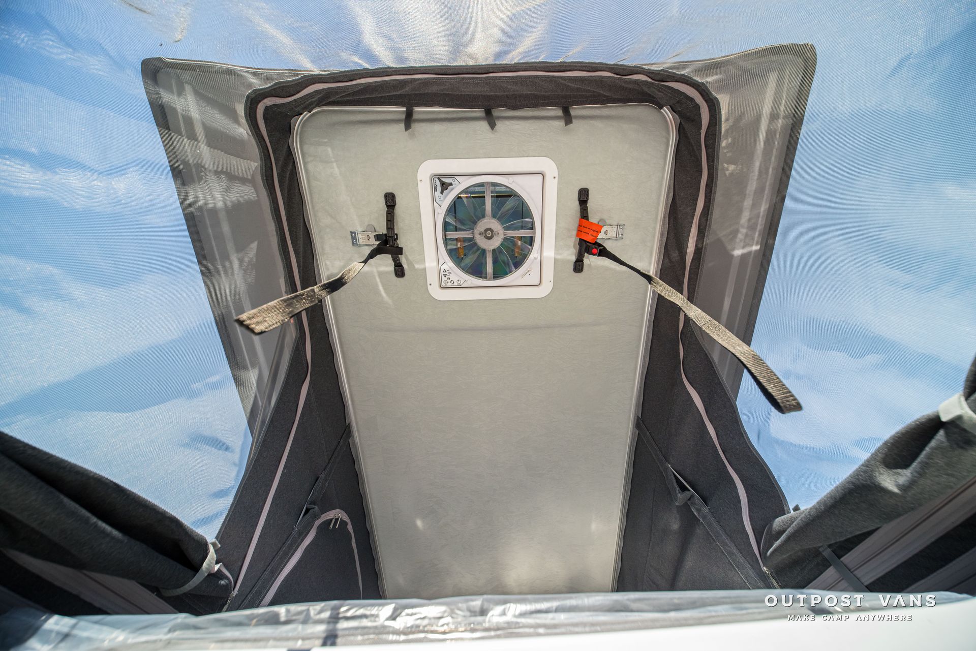 Interior view of a tent roof vent with a fan and straps.