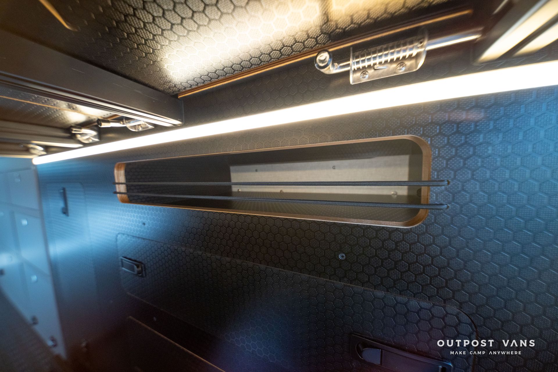 Interior view with a rectangular slot, a glowing light, and textured black paneling.