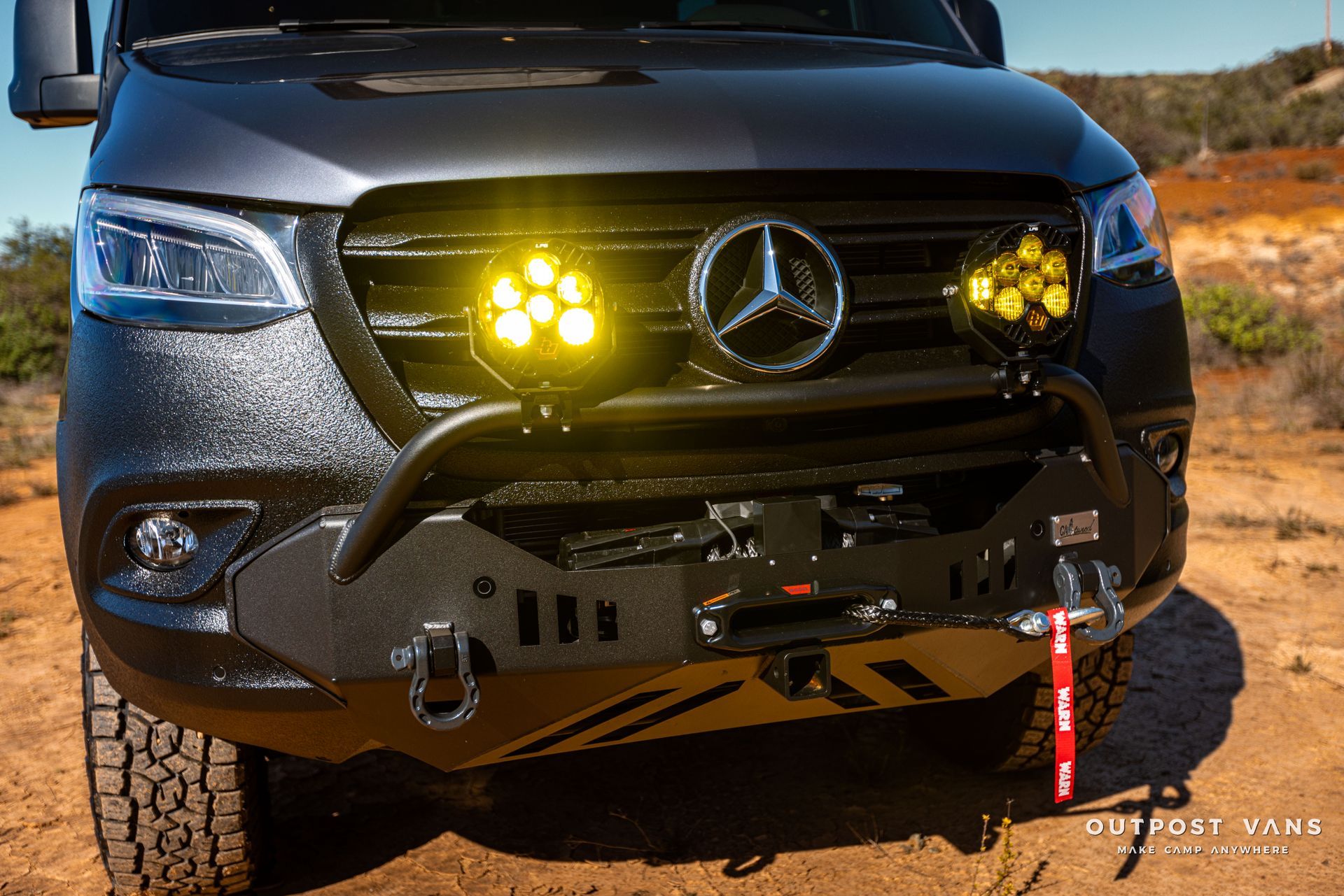 a black mercedes sprinter van with yellow lights on the front bumper .