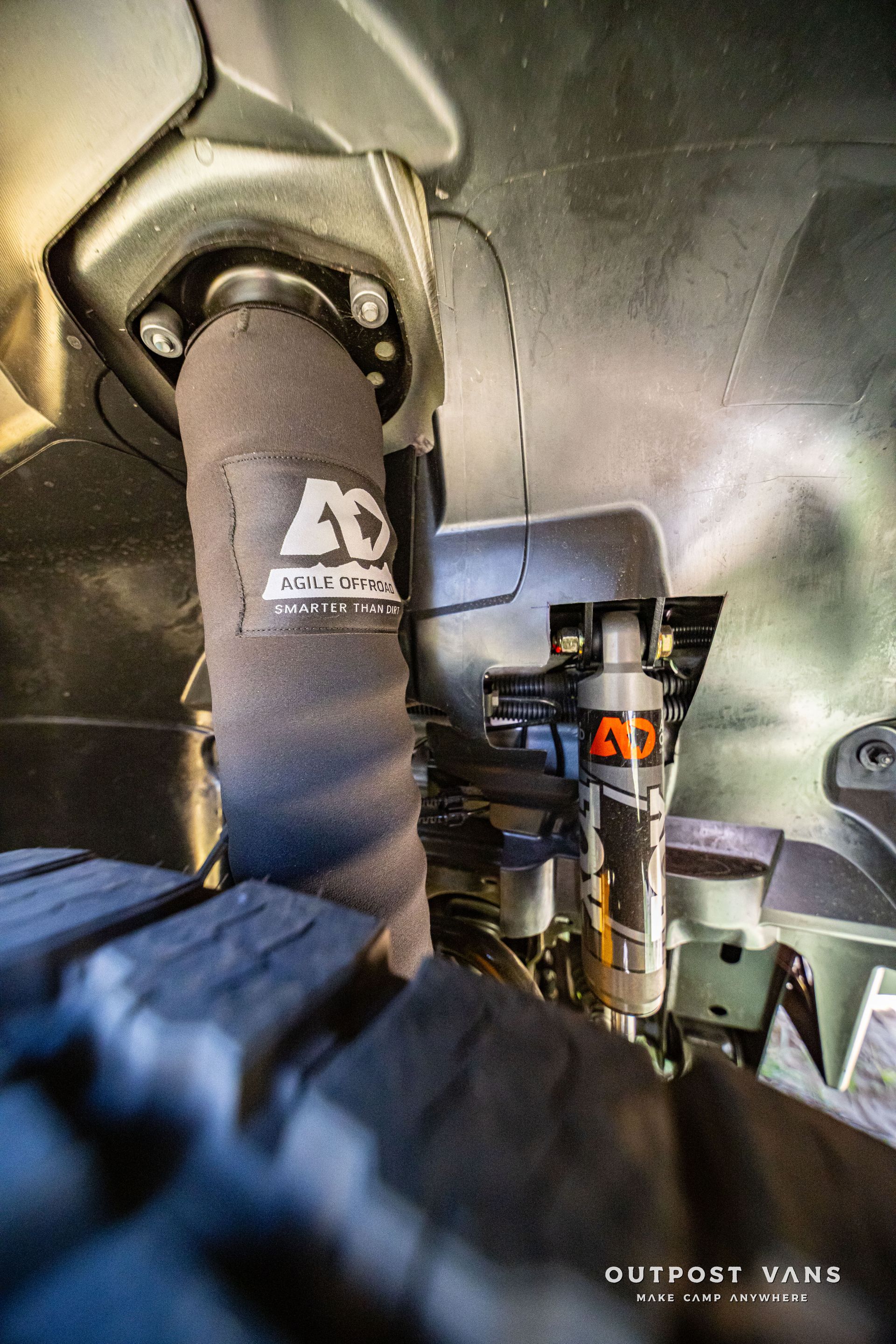 Tactical gear inside a vehicle, with a black seatbelt and mounted equipment in view.