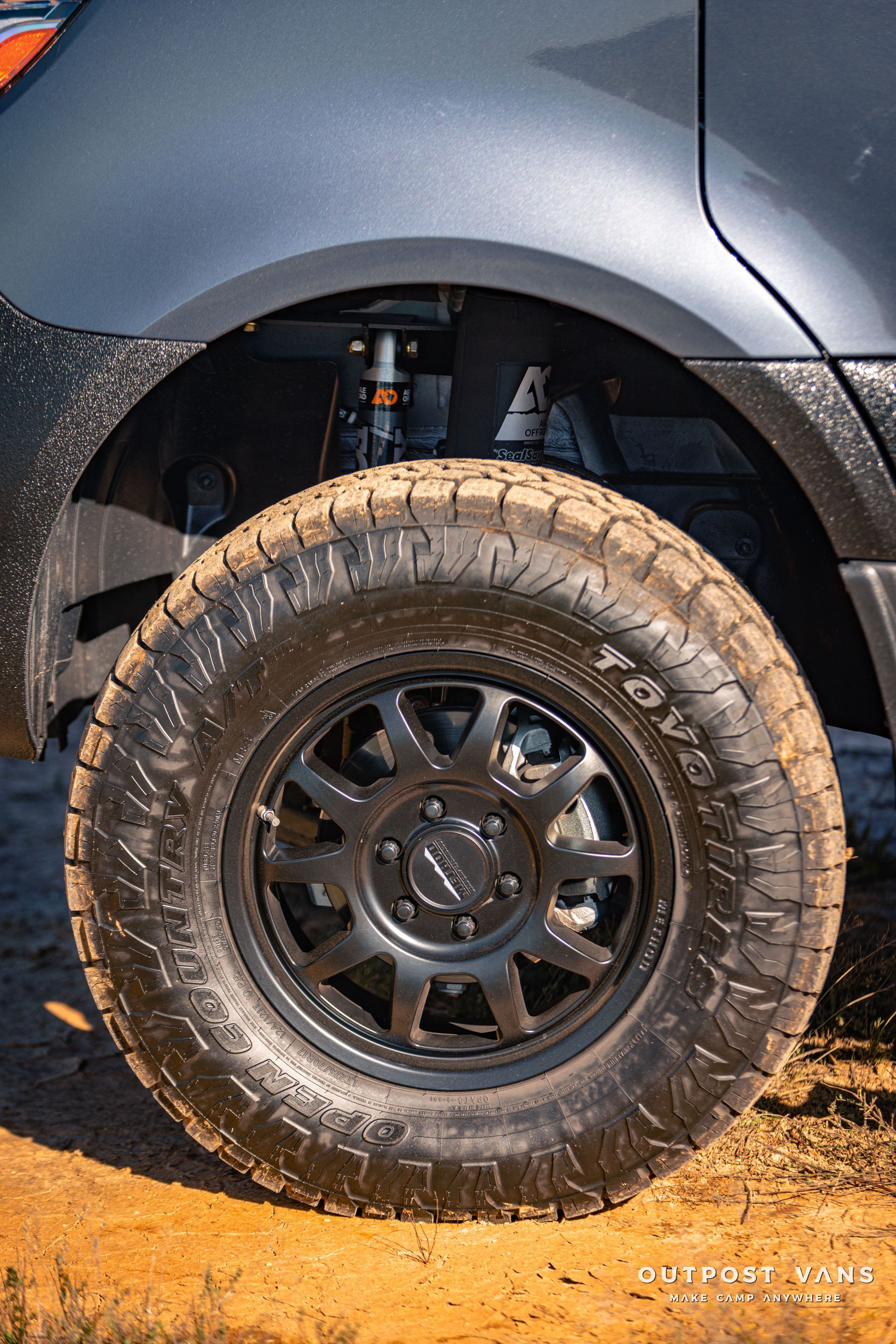 a close up of a tire on a car on a dirt road .