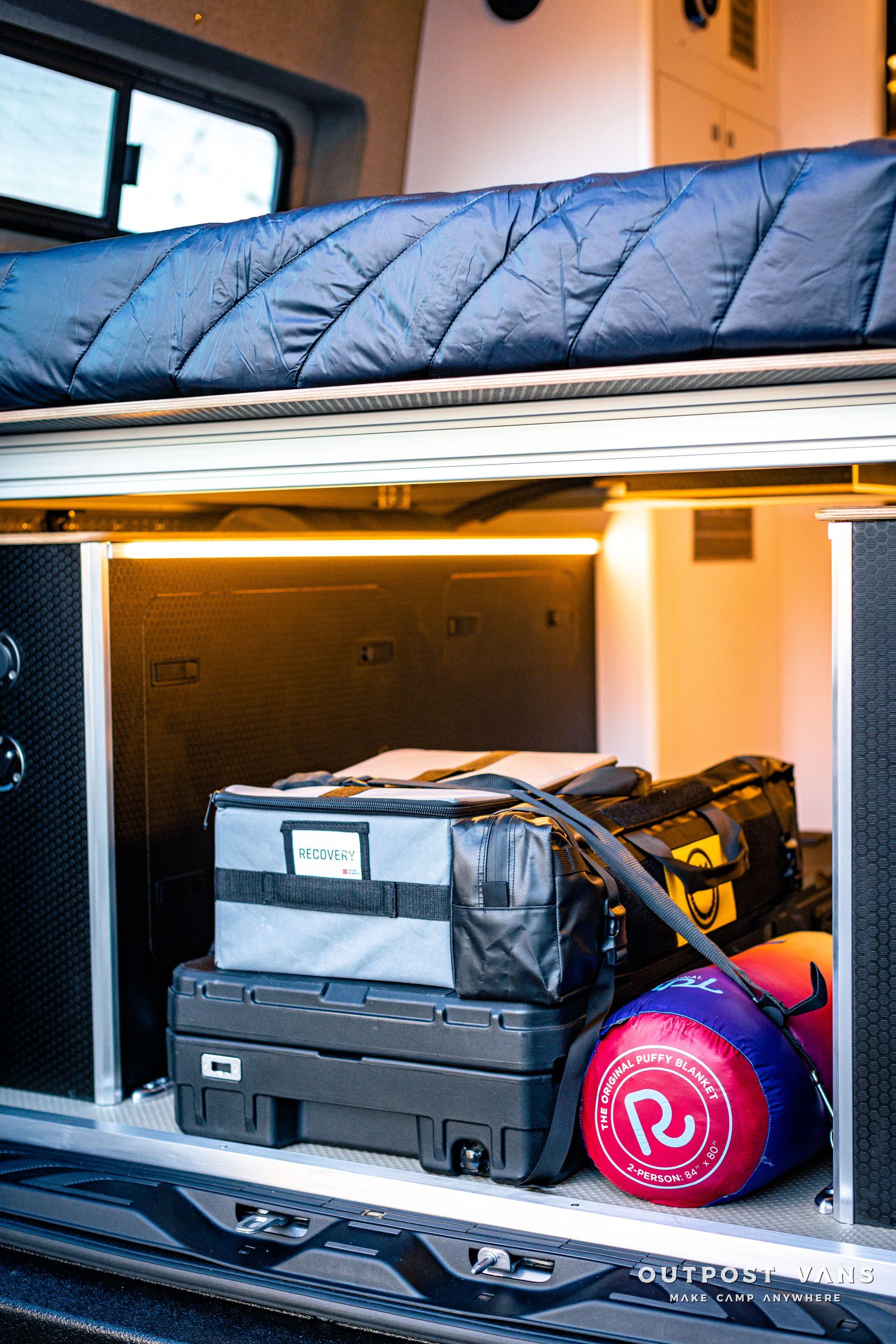 a van with a bed and a bunch of luggage in the back .