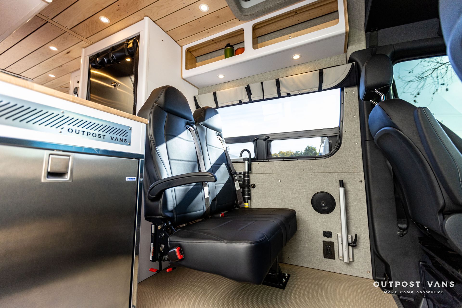 the inside of a van with a seat and a refrigerator .