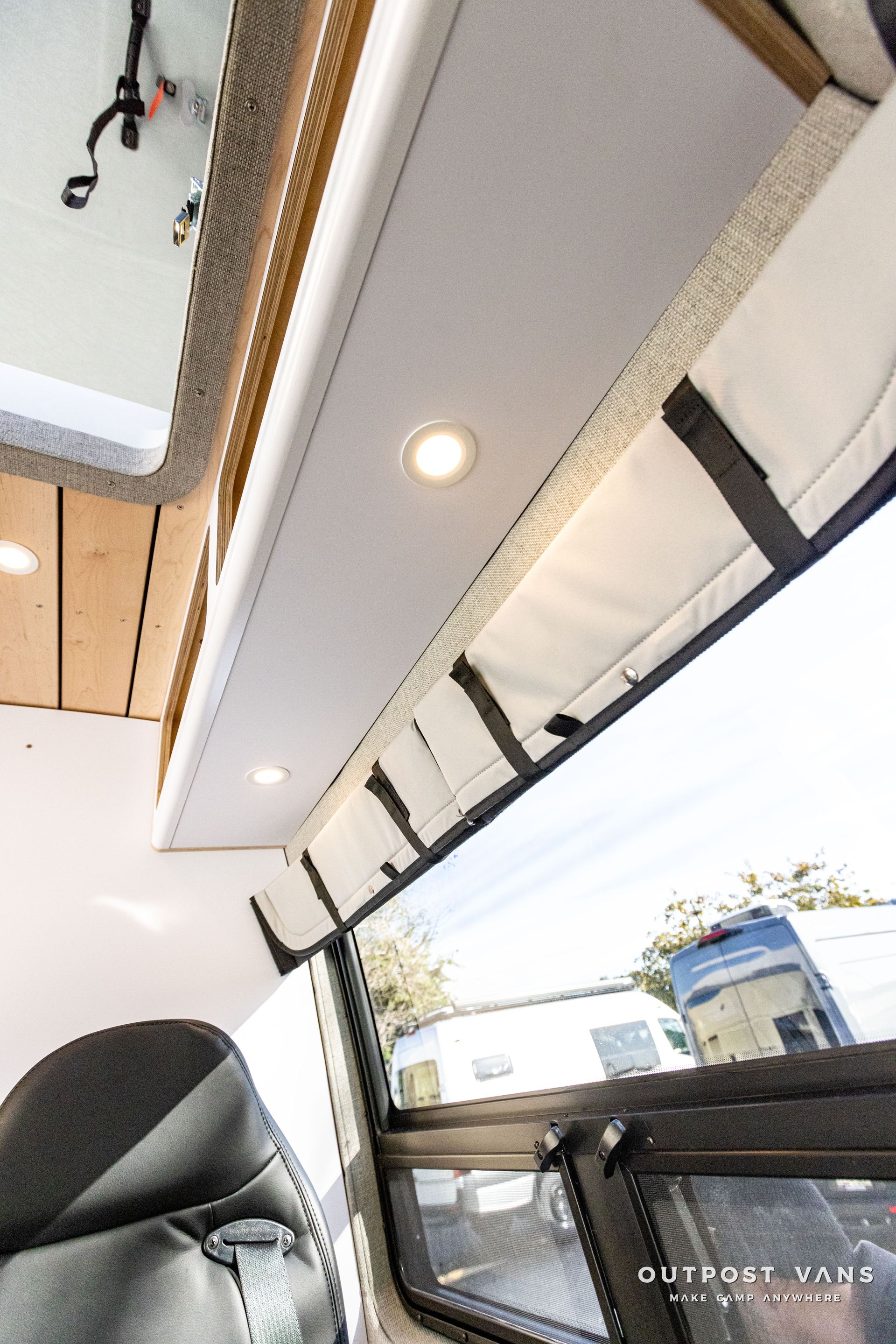 the inside of a camper van with a window and a ceiling shelf .