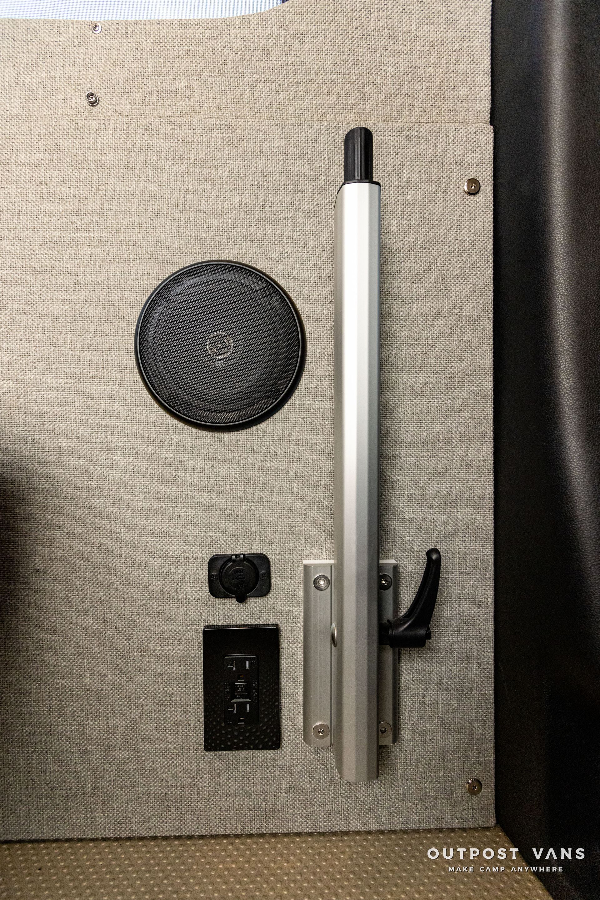 a metal pole is sitting on top of a carpet next to a speaker .