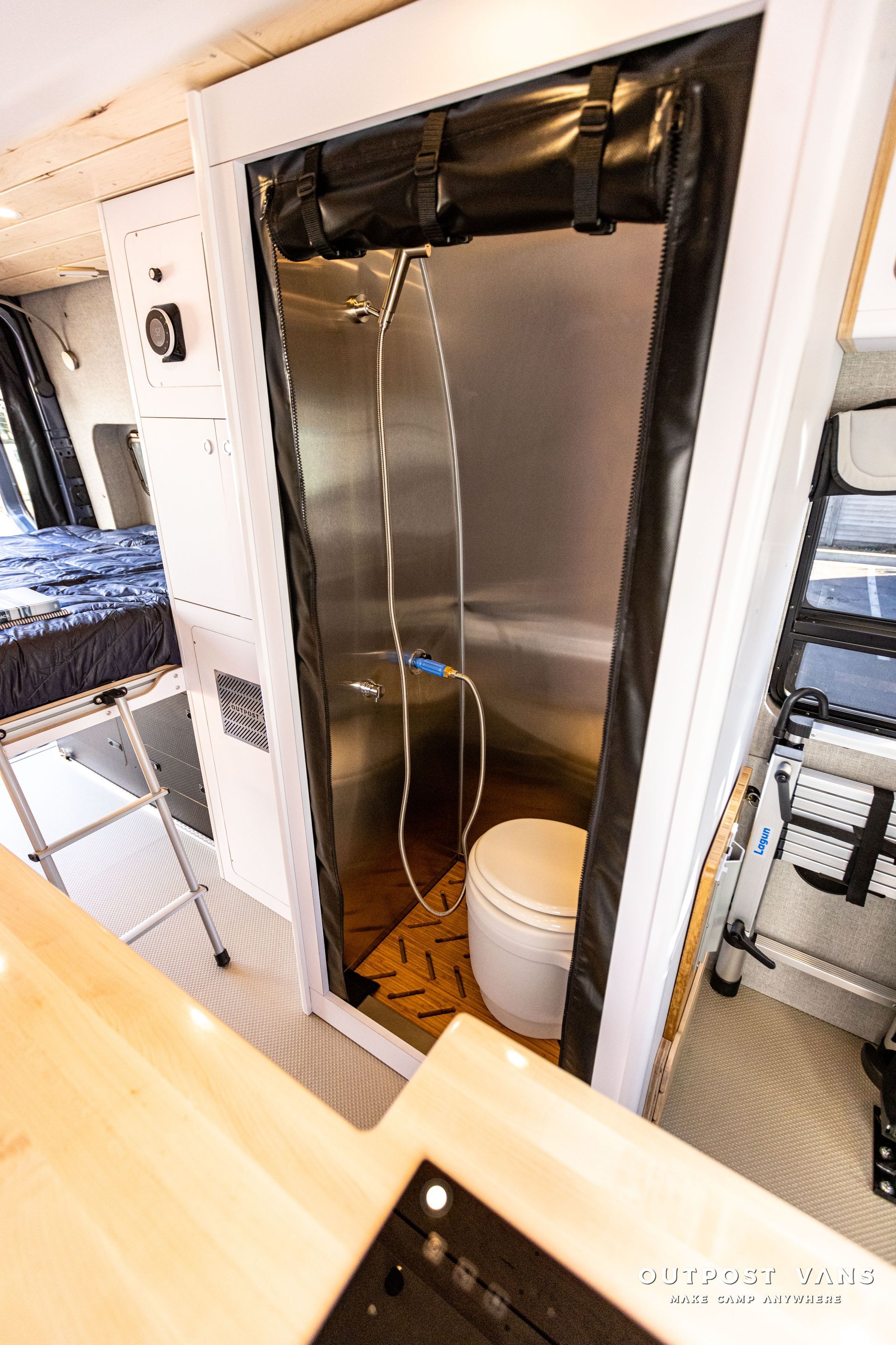 a bathroom in a van with a toilet and shower .