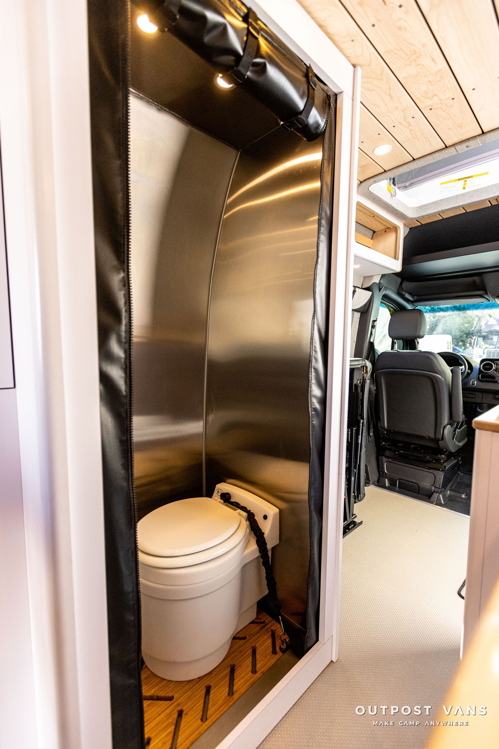 a bathroom in a van with a toilet and shower .