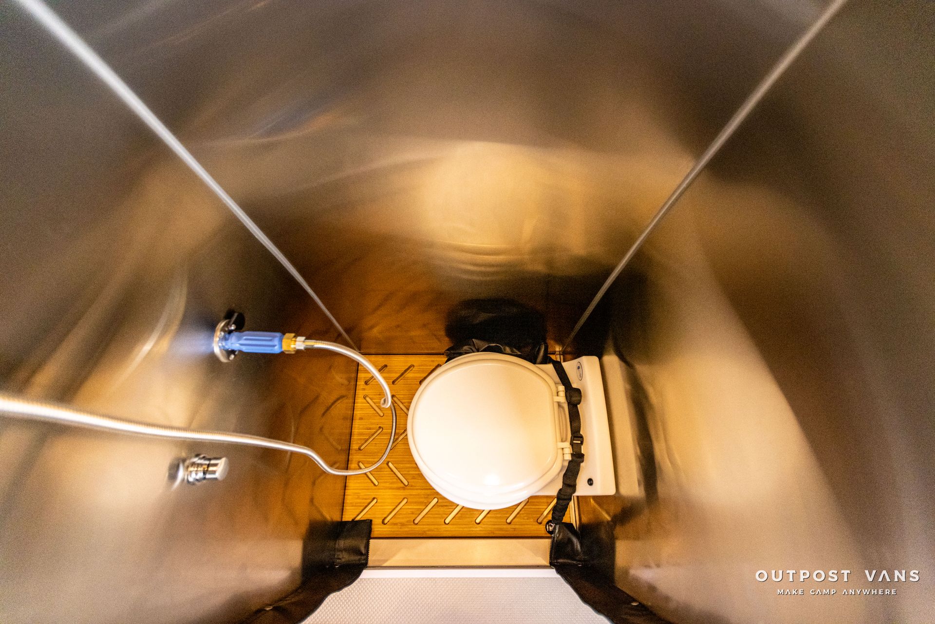 a stainless steel toilet with a blue hose attached to it .
