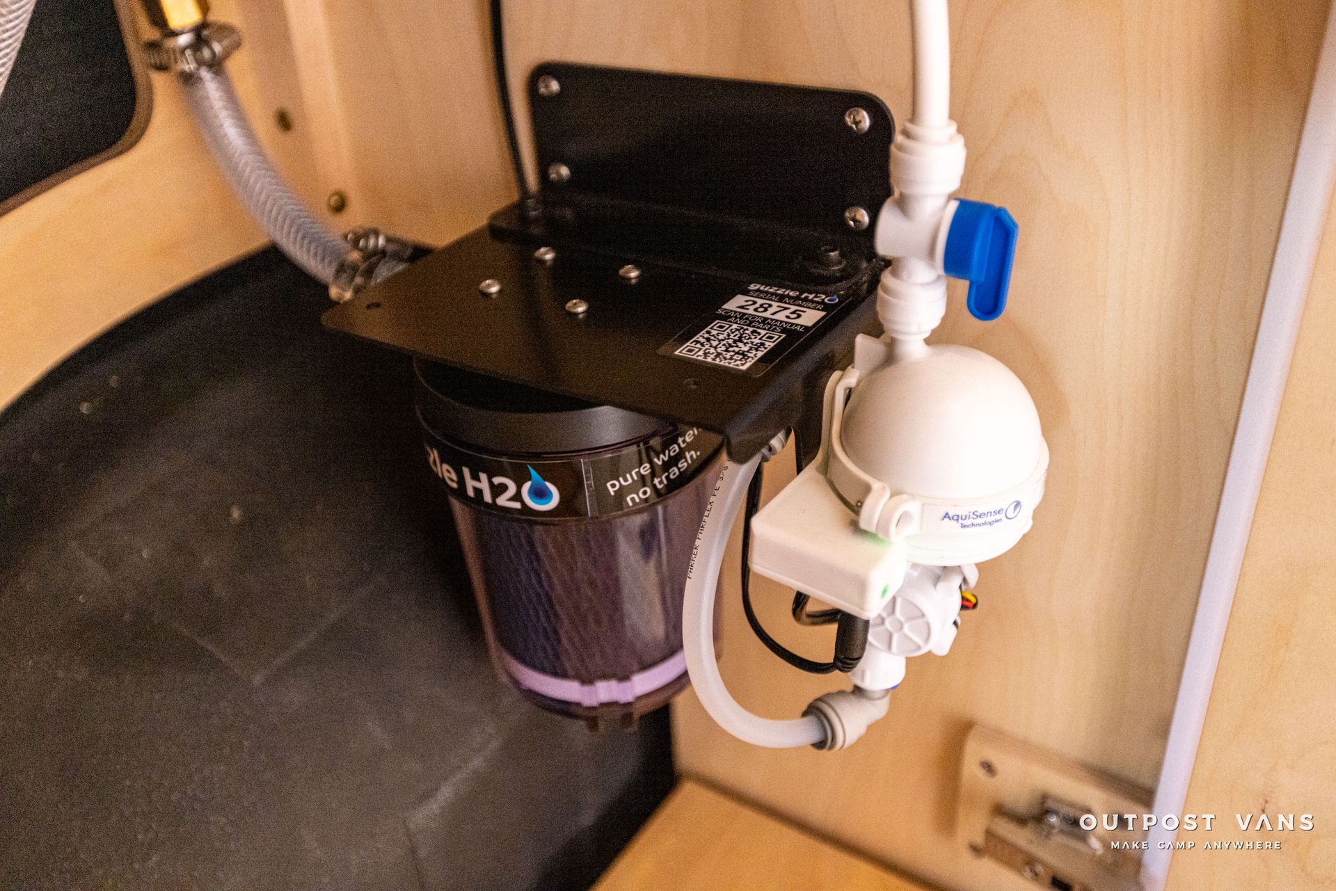 a water filter is attached to a wall in a bathroom .