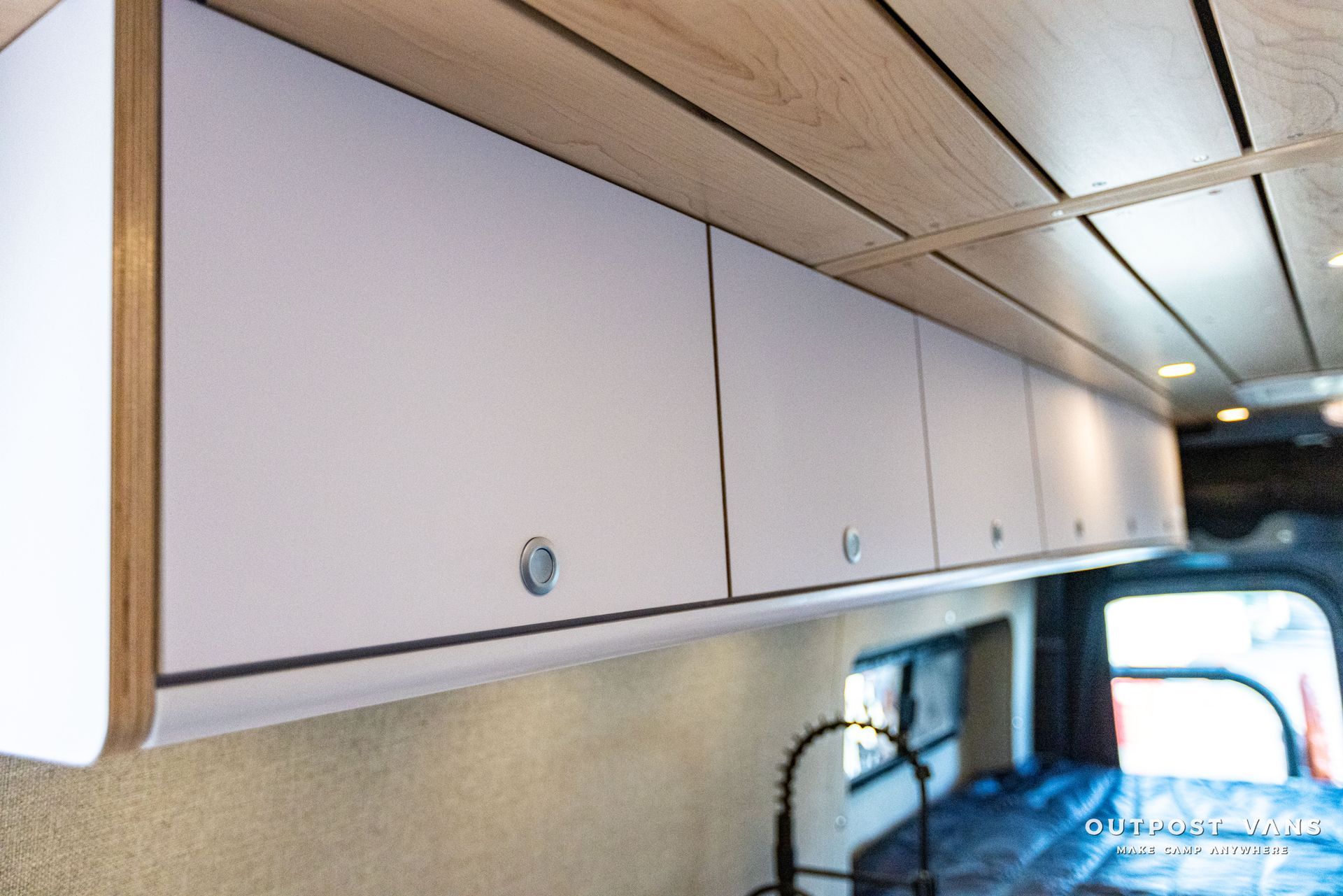 a van with white cabinets and a wooden ceiling