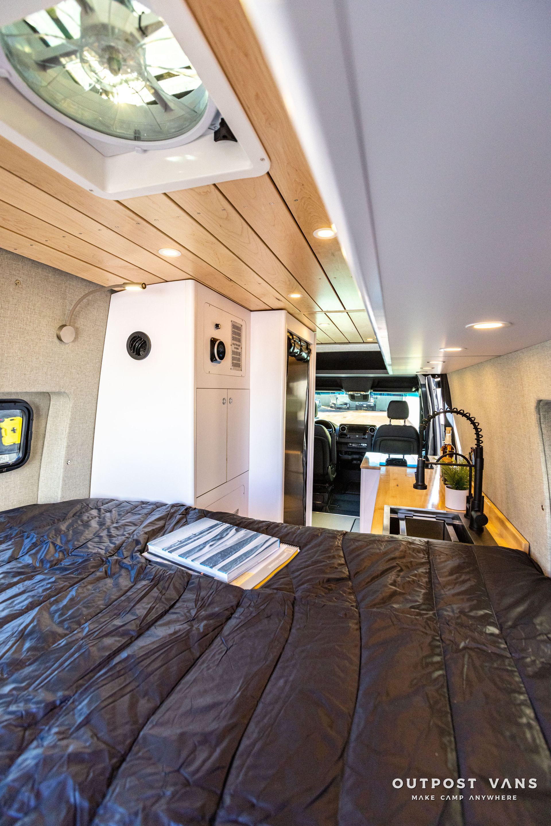 a camper van with a bed and a fan on the ceiling .