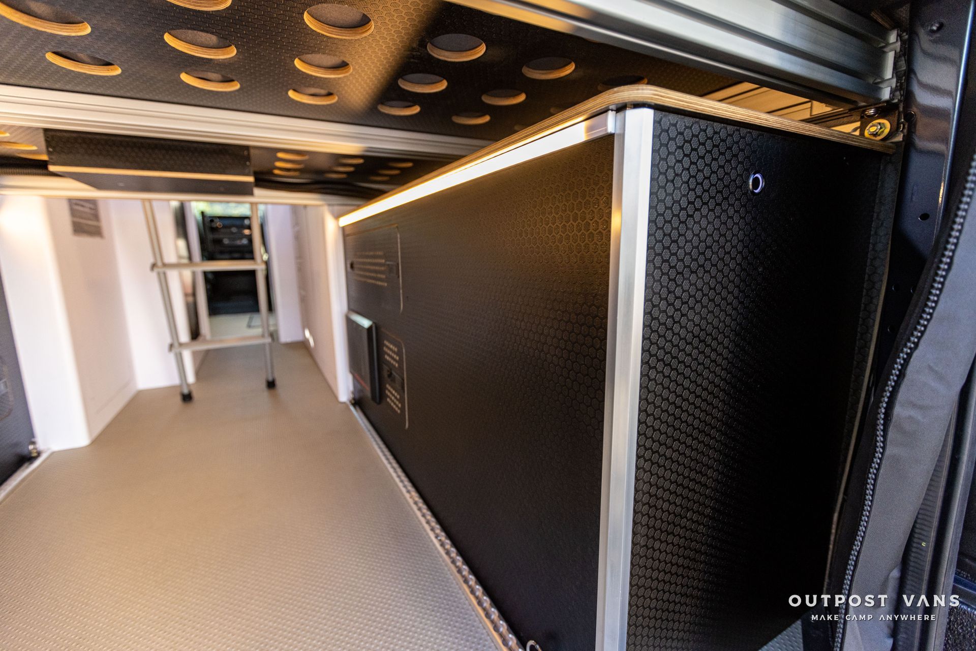 the inside of a van with a ladder and a shelf .