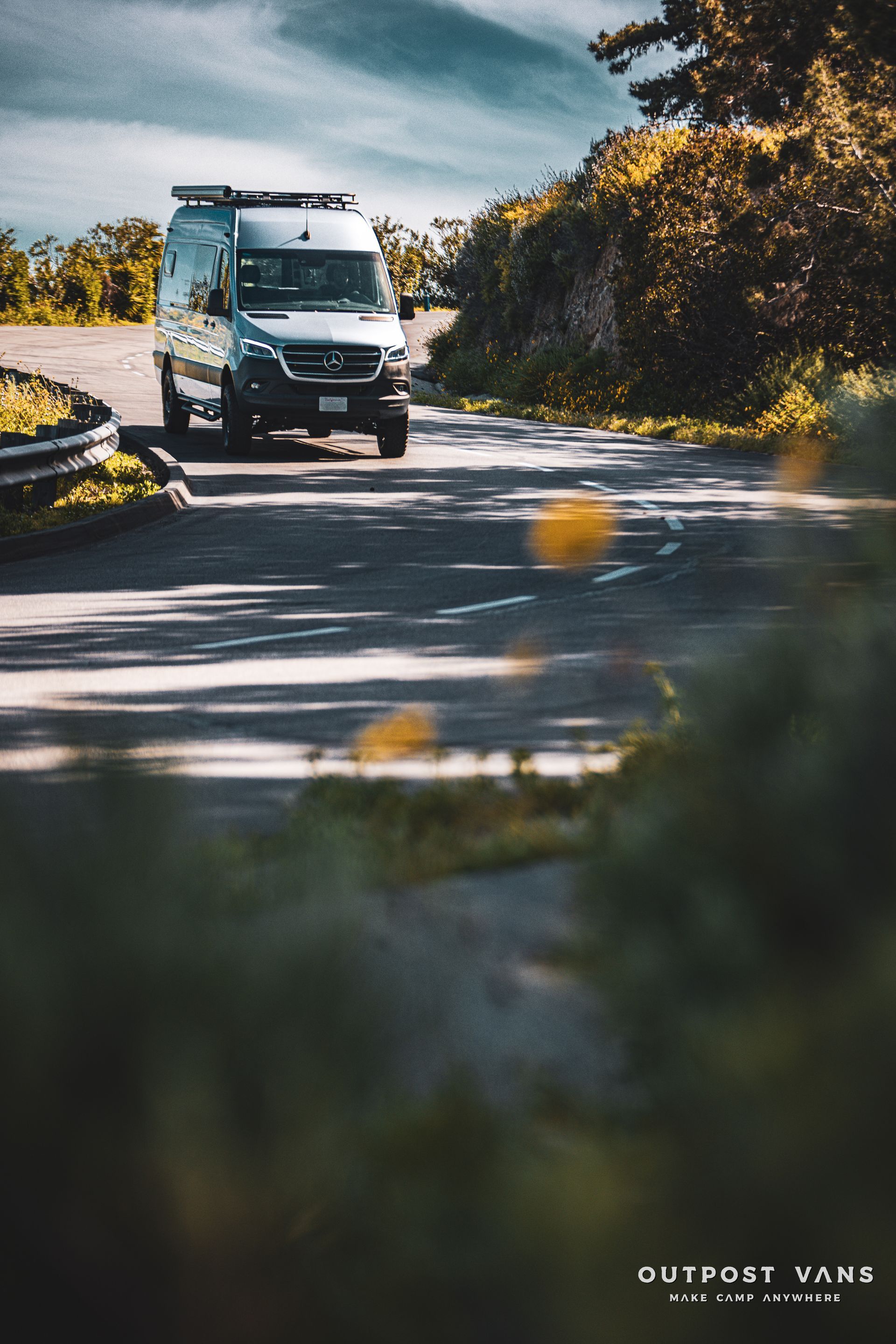 a white van is driving down a curvy road .