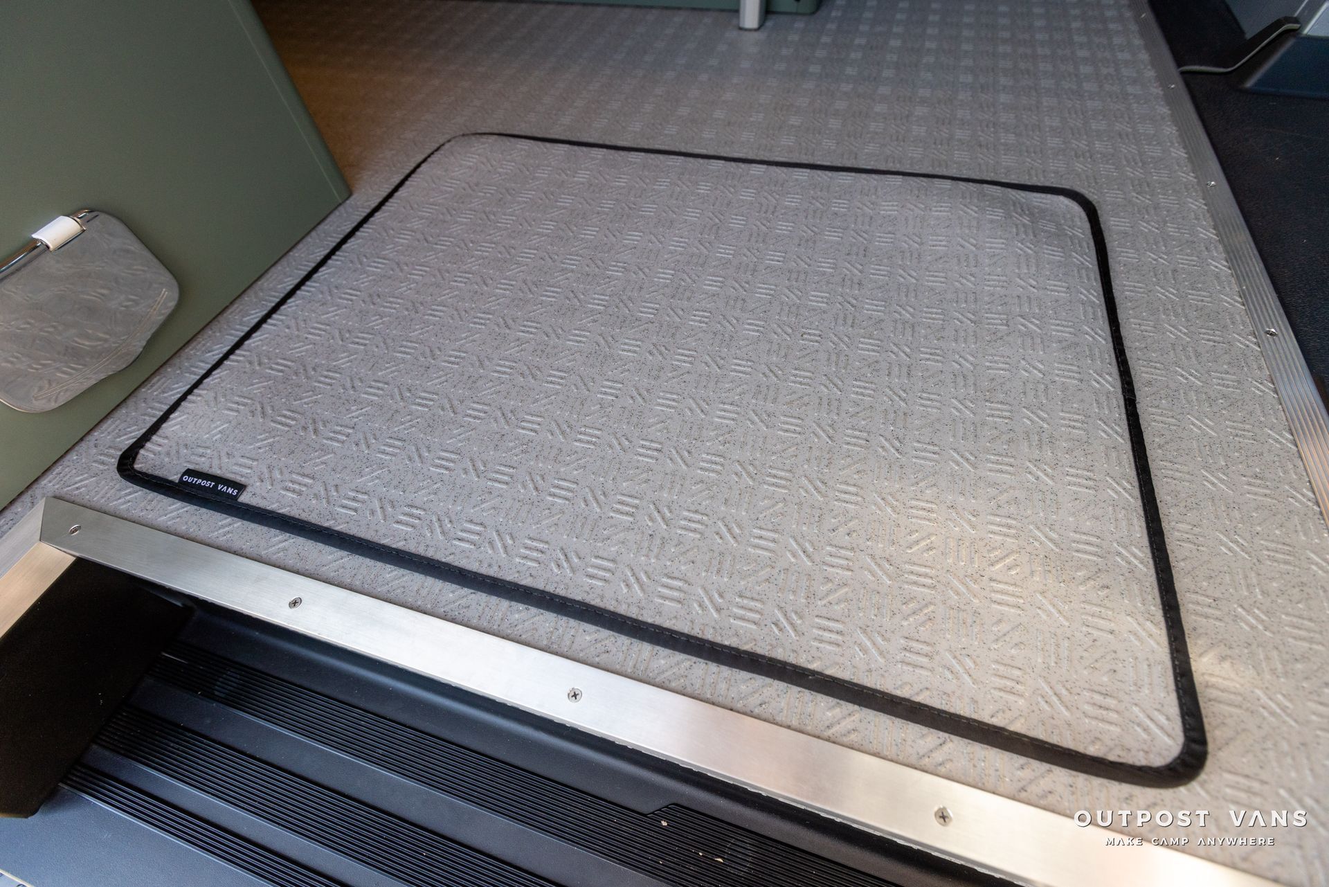 a gray carpeted floor with a black border and a metal trim .
