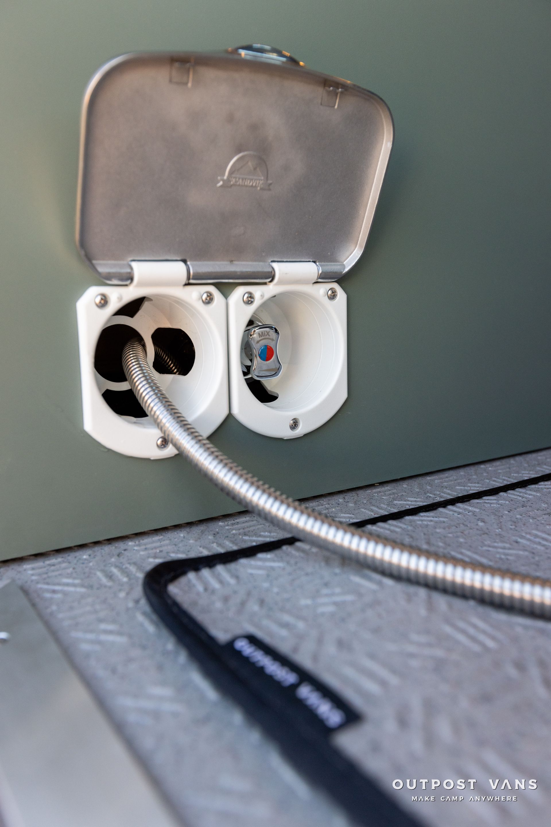 a hose is connected to a electrical outlet on a wall .