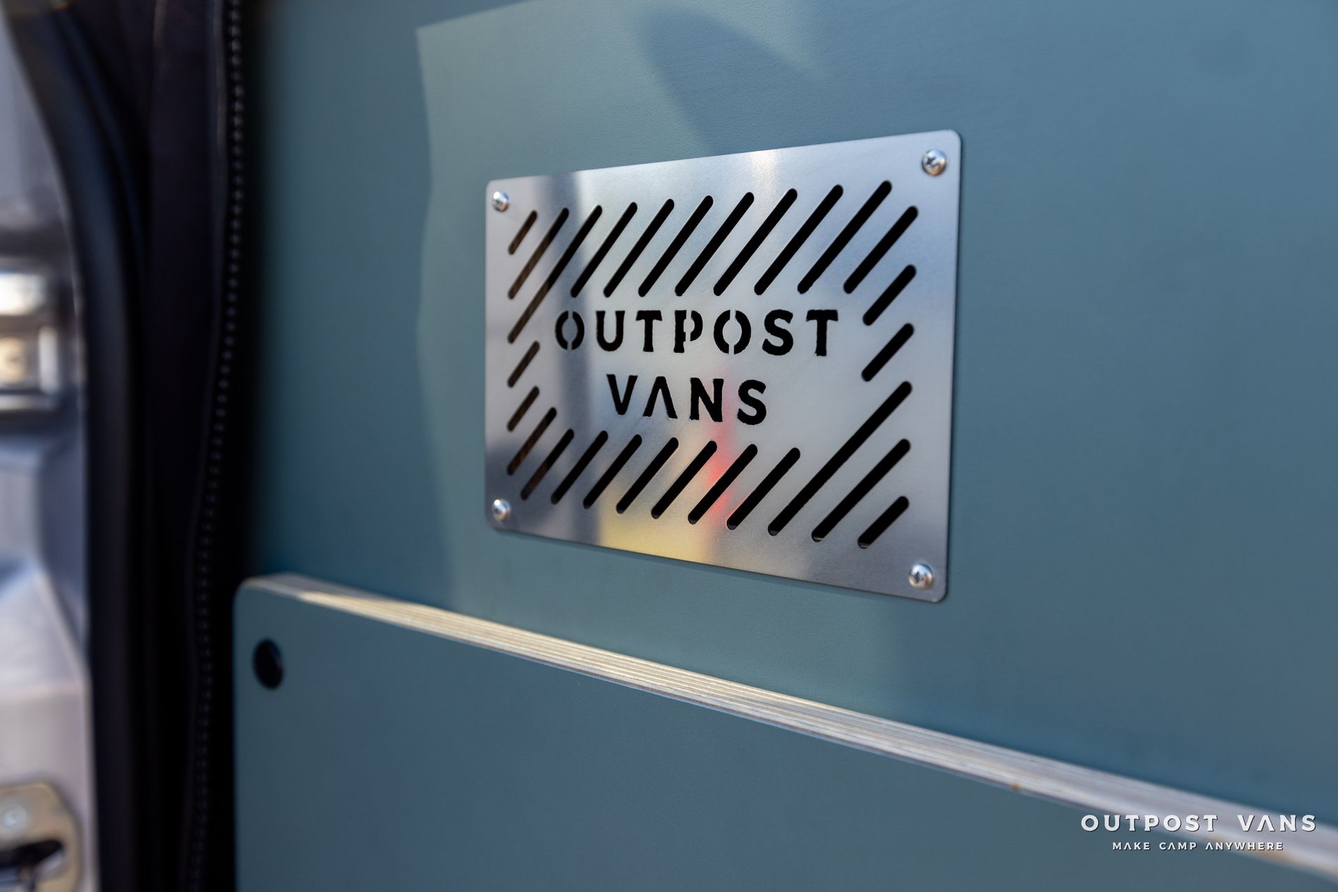 a sign on the side of a van that says outpost vans