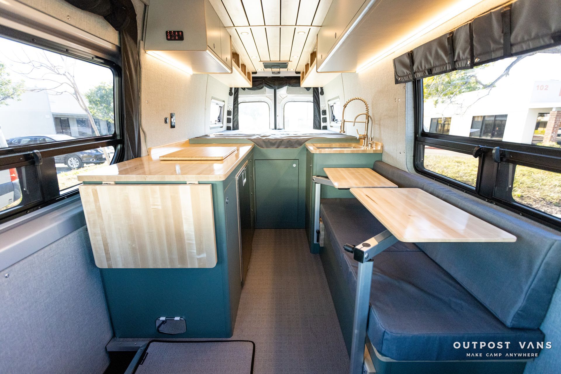 the inside of a camper van with a table and a sink .