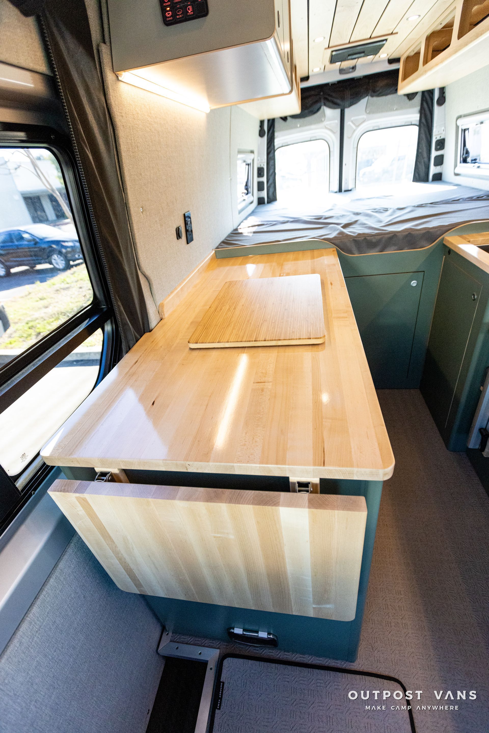 the inside of a van with a wooden table and benches .