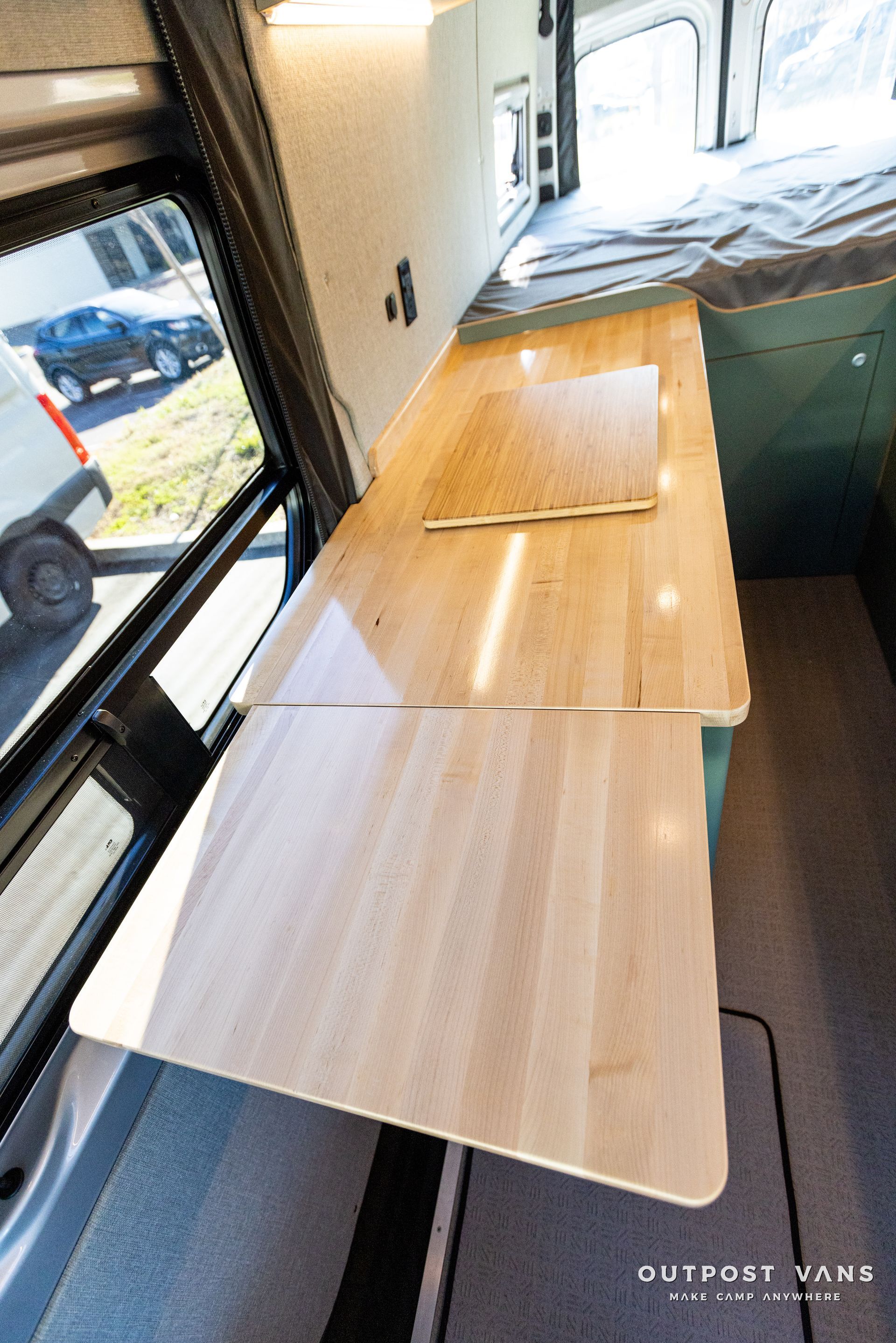 a wooden table is sitting in the back of a van .