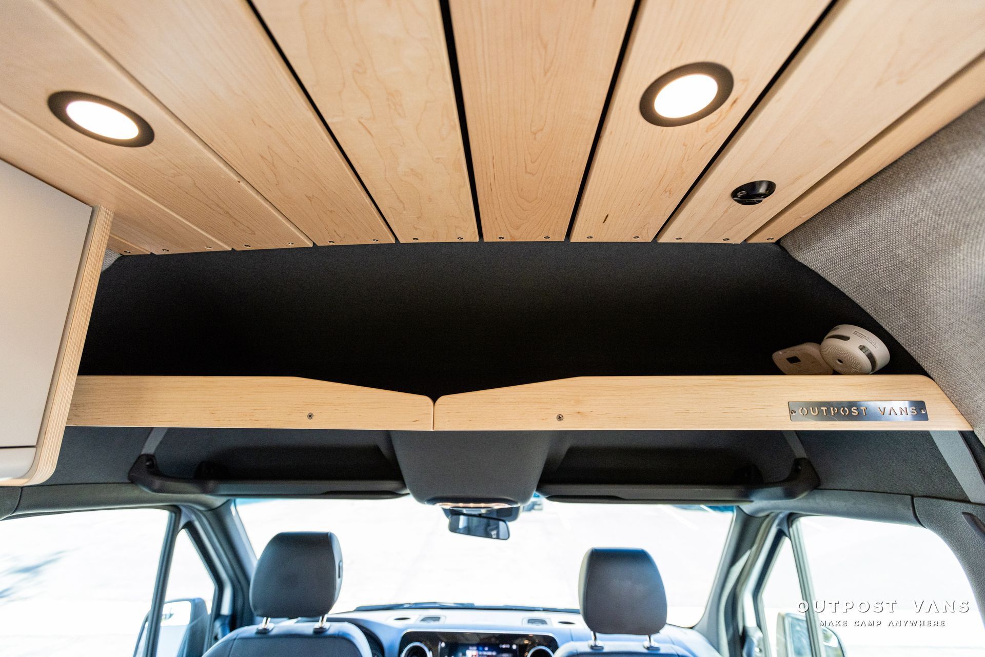 a car with a wooden ceiling and a bed in the back .