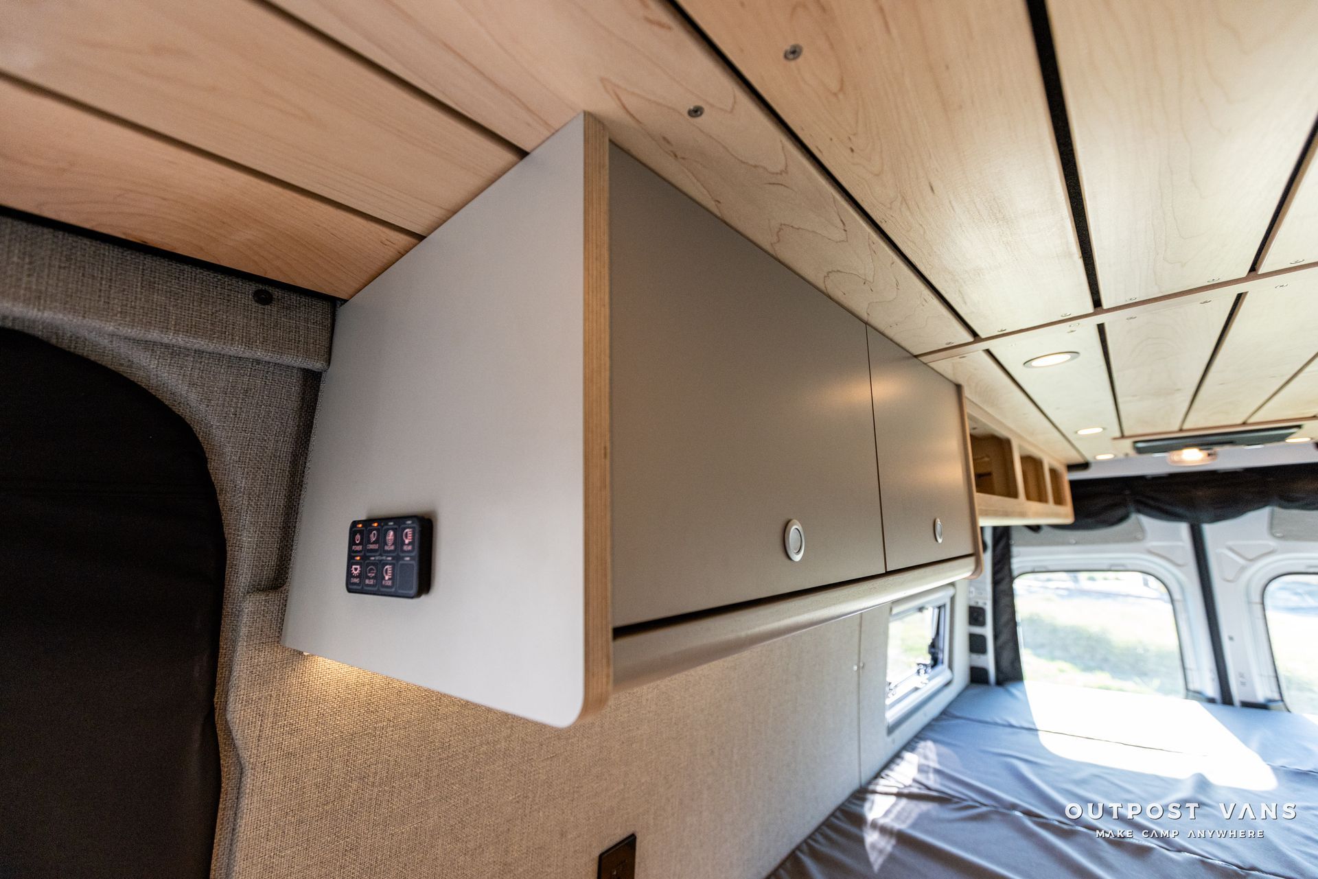 the inside of a van with a wooden ceiling and cabinets .