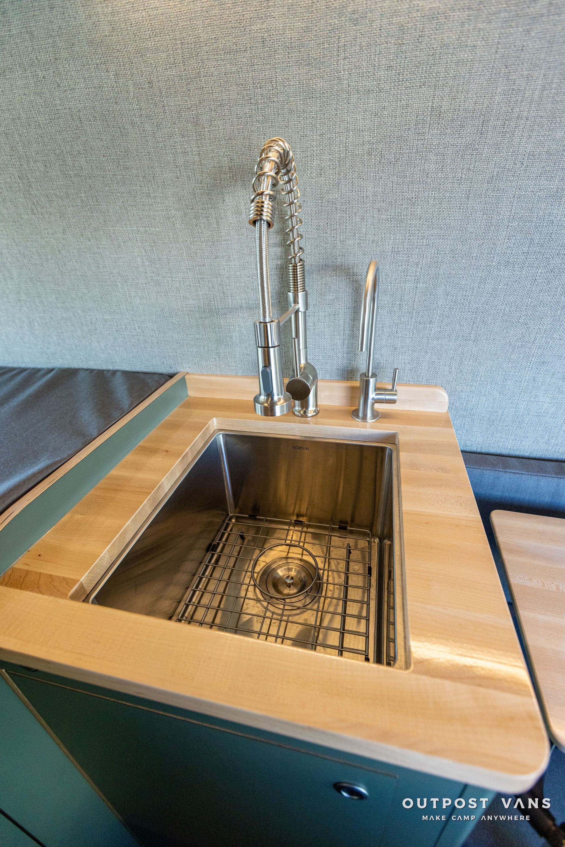 a kitchen sink with a wooden counter top and a faucet .