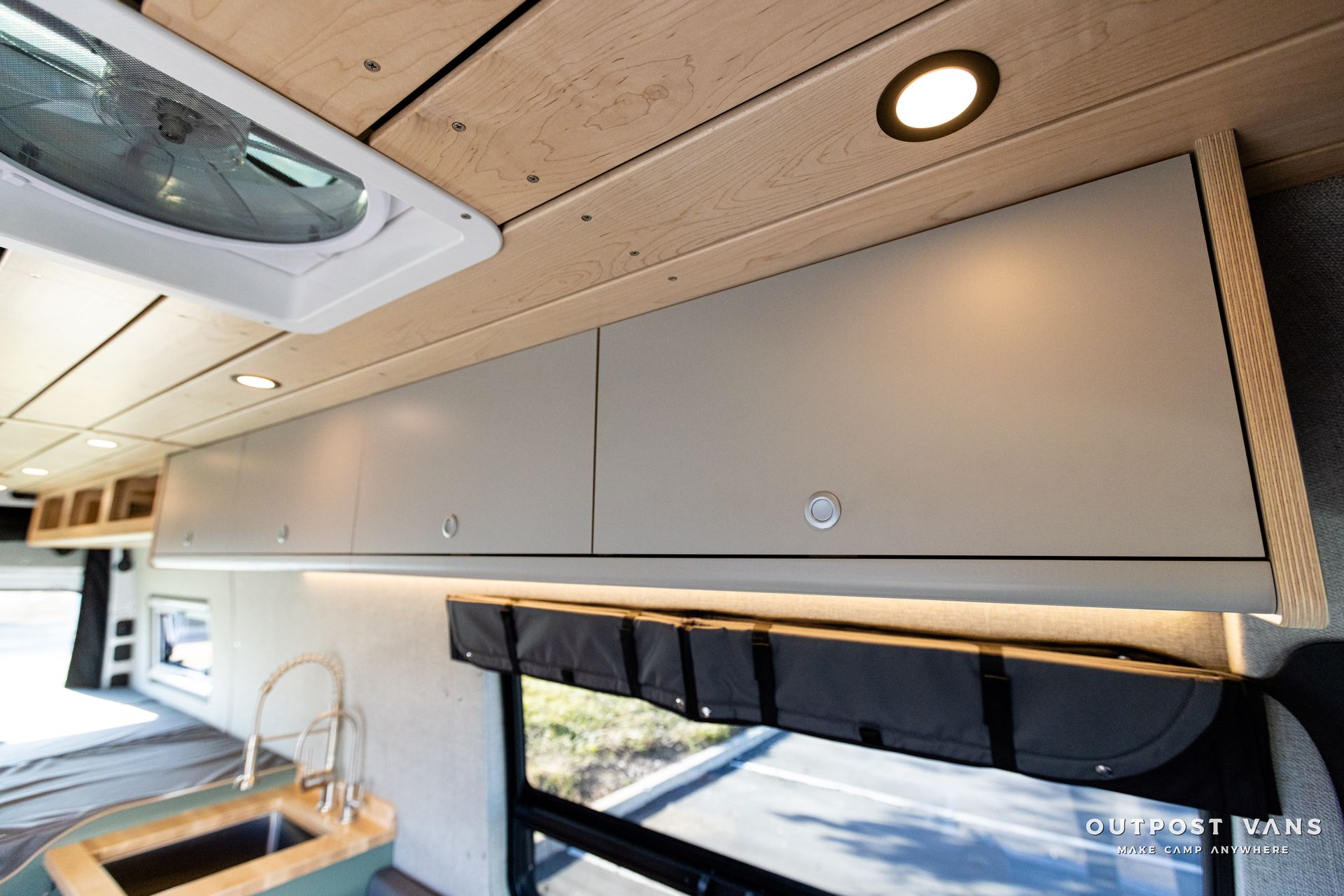 a van with a sink , cabinets , and a fan on the ceiling .