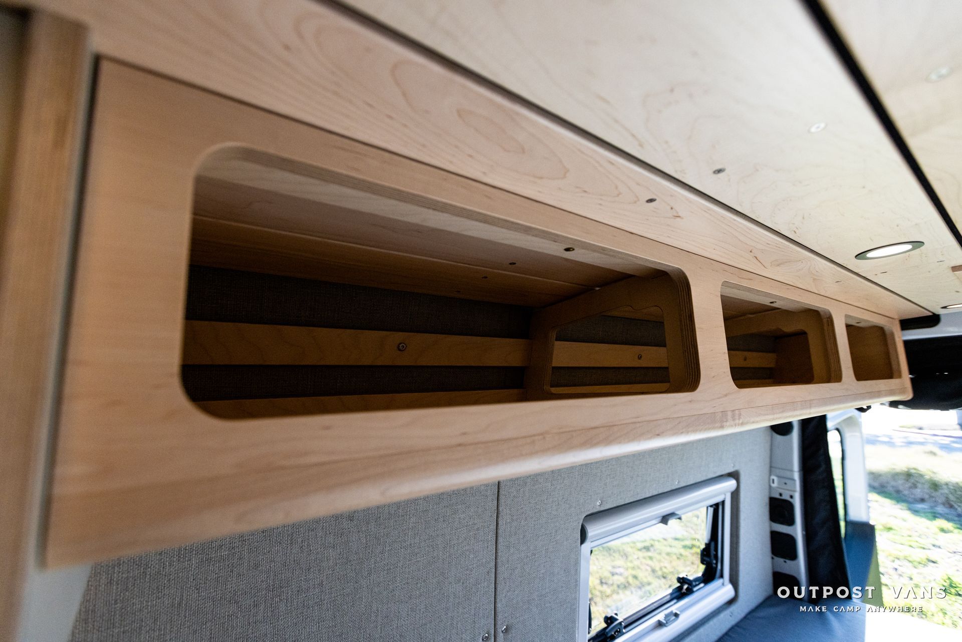 a wooden shelf is hanging from the ceiling of a van .