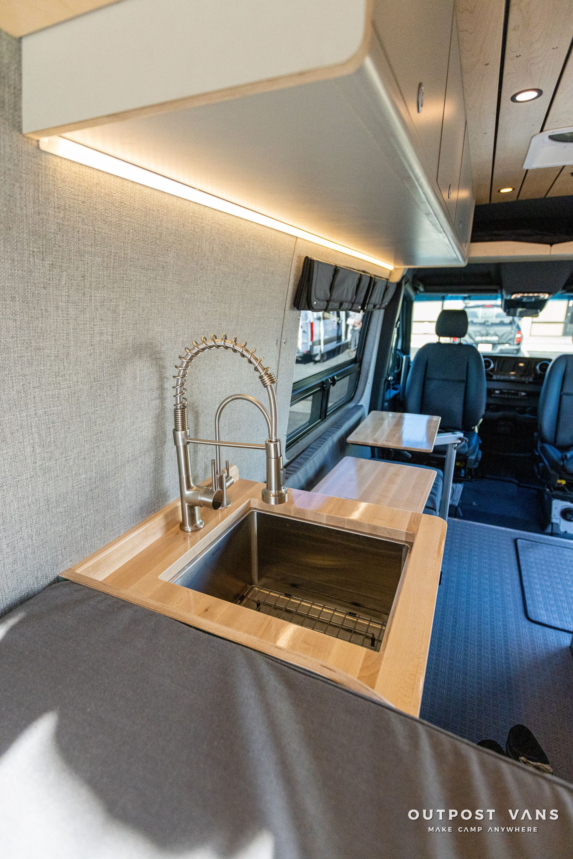 a kitchen in a van with a sink and a table .
