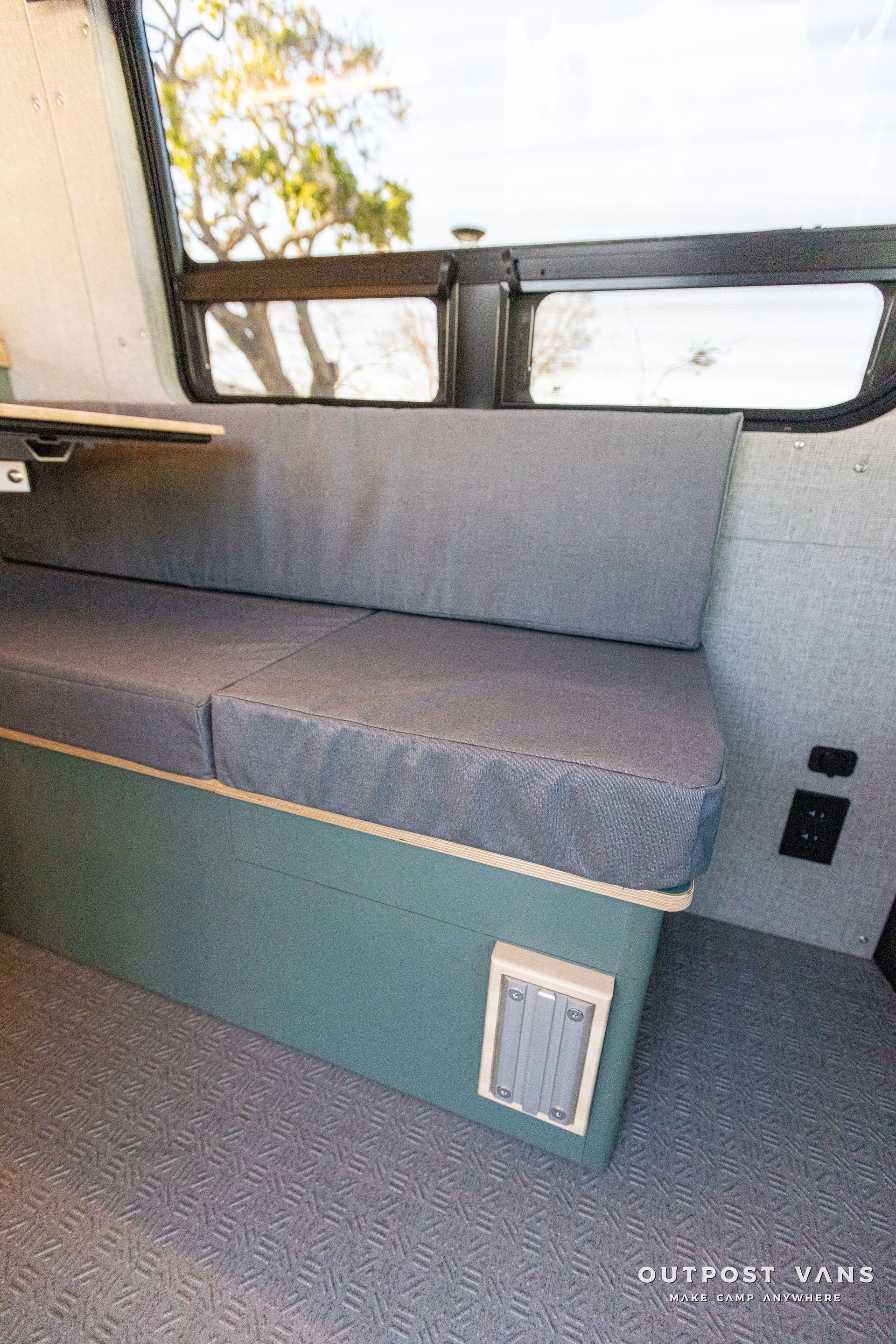 a couch in the back of a bus with a window .