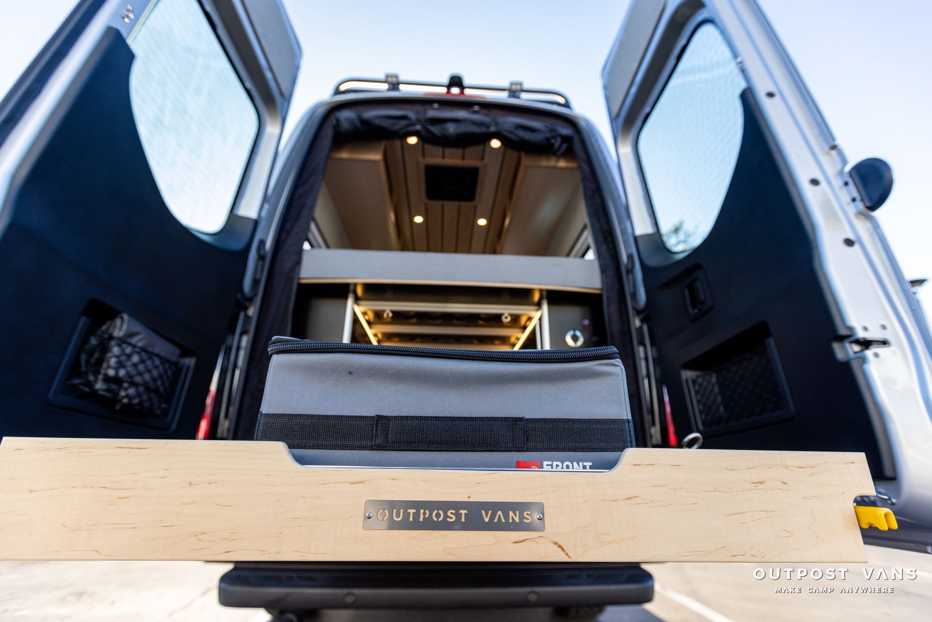 the back of a van with its doors open and a wooden box in the back .