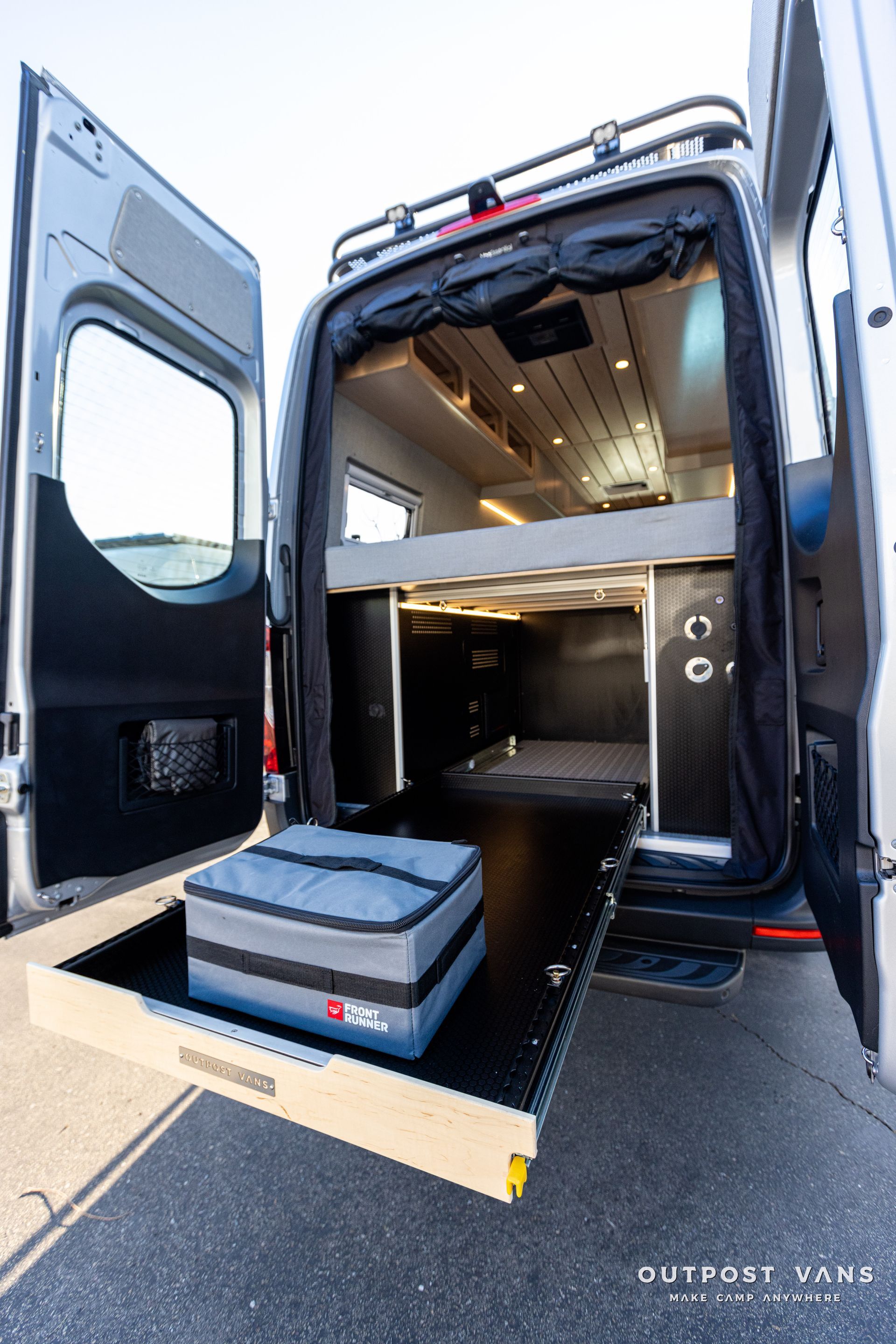 the back of a van with the door open and a mattress in the back .