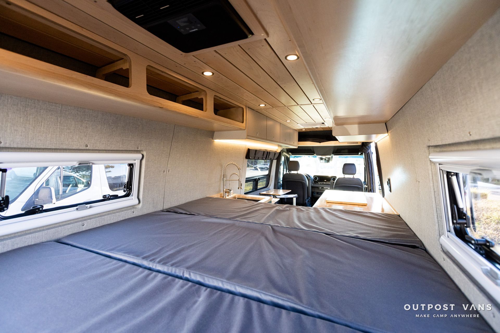 the inside of a van with a bed and a kitchen .
