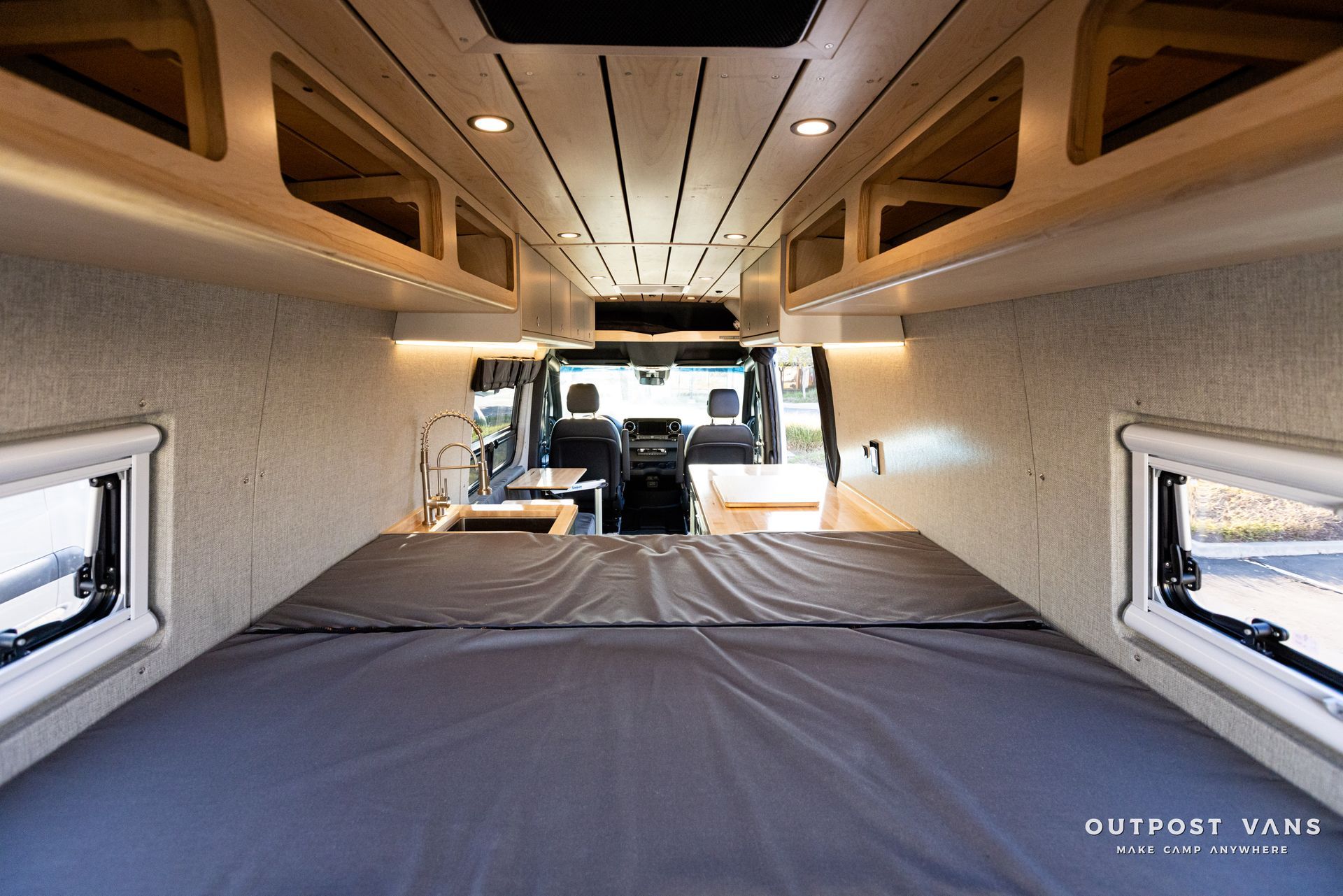 the inside of a van with a bed and a kitchen .