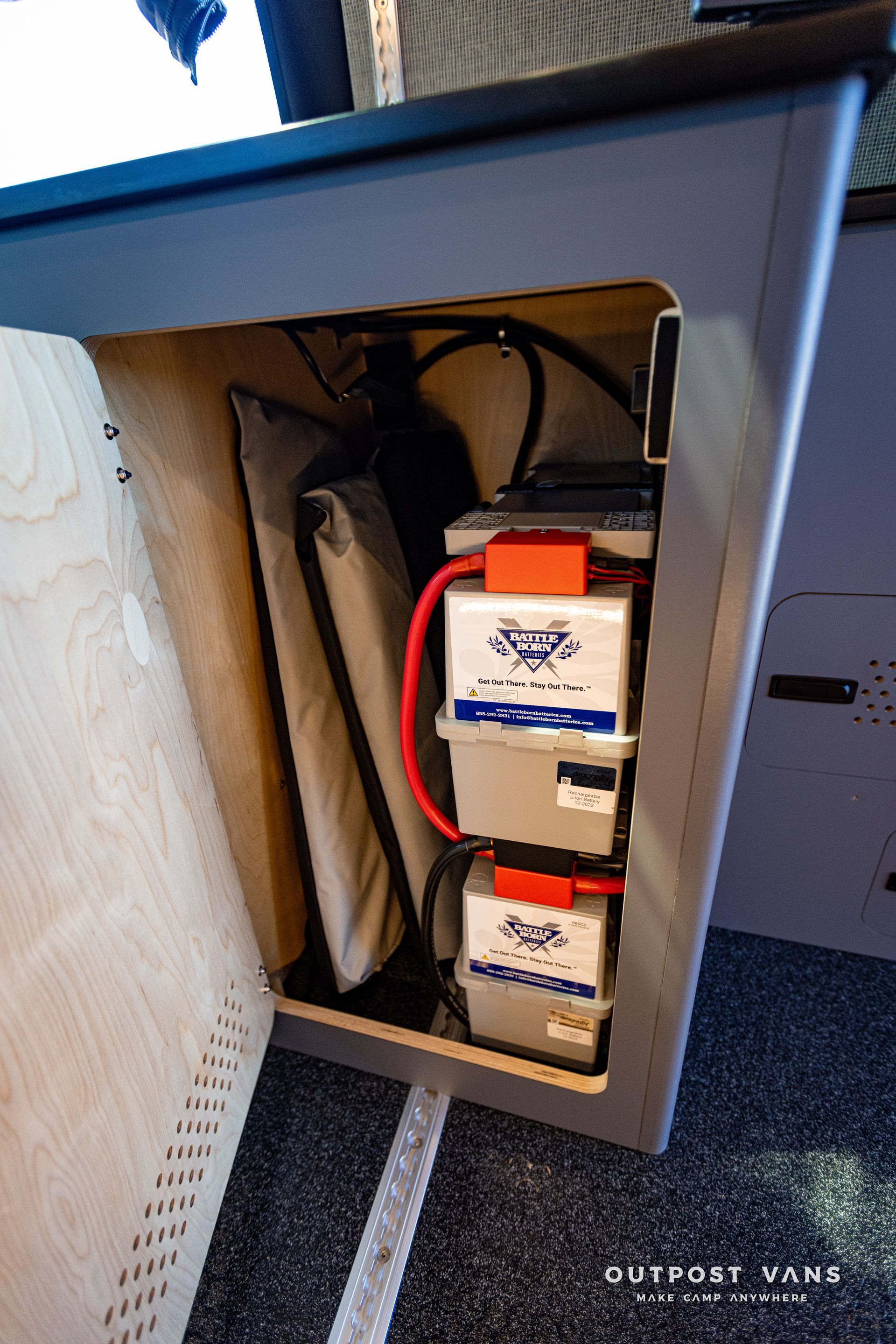 three batteries are stacked on top of each other in a cabinet .