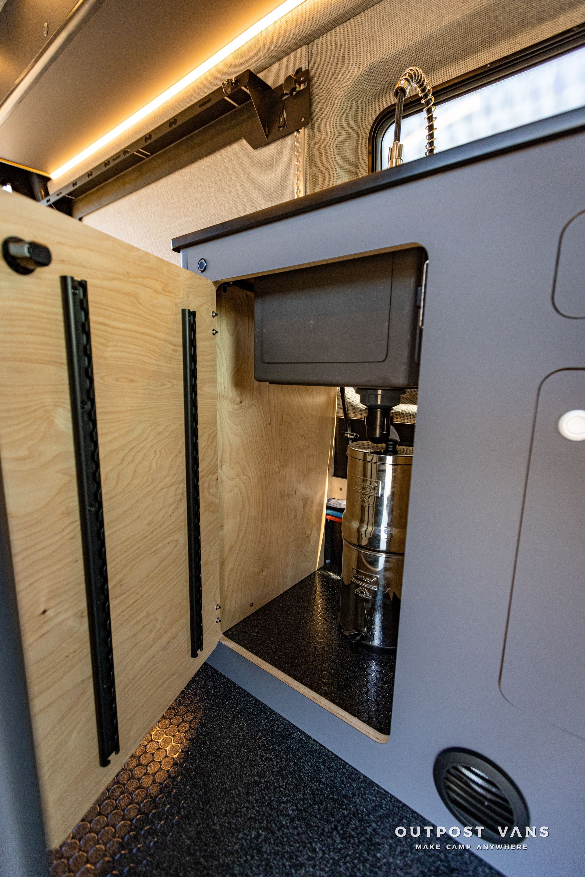 a sink is under a cabinet in a van .