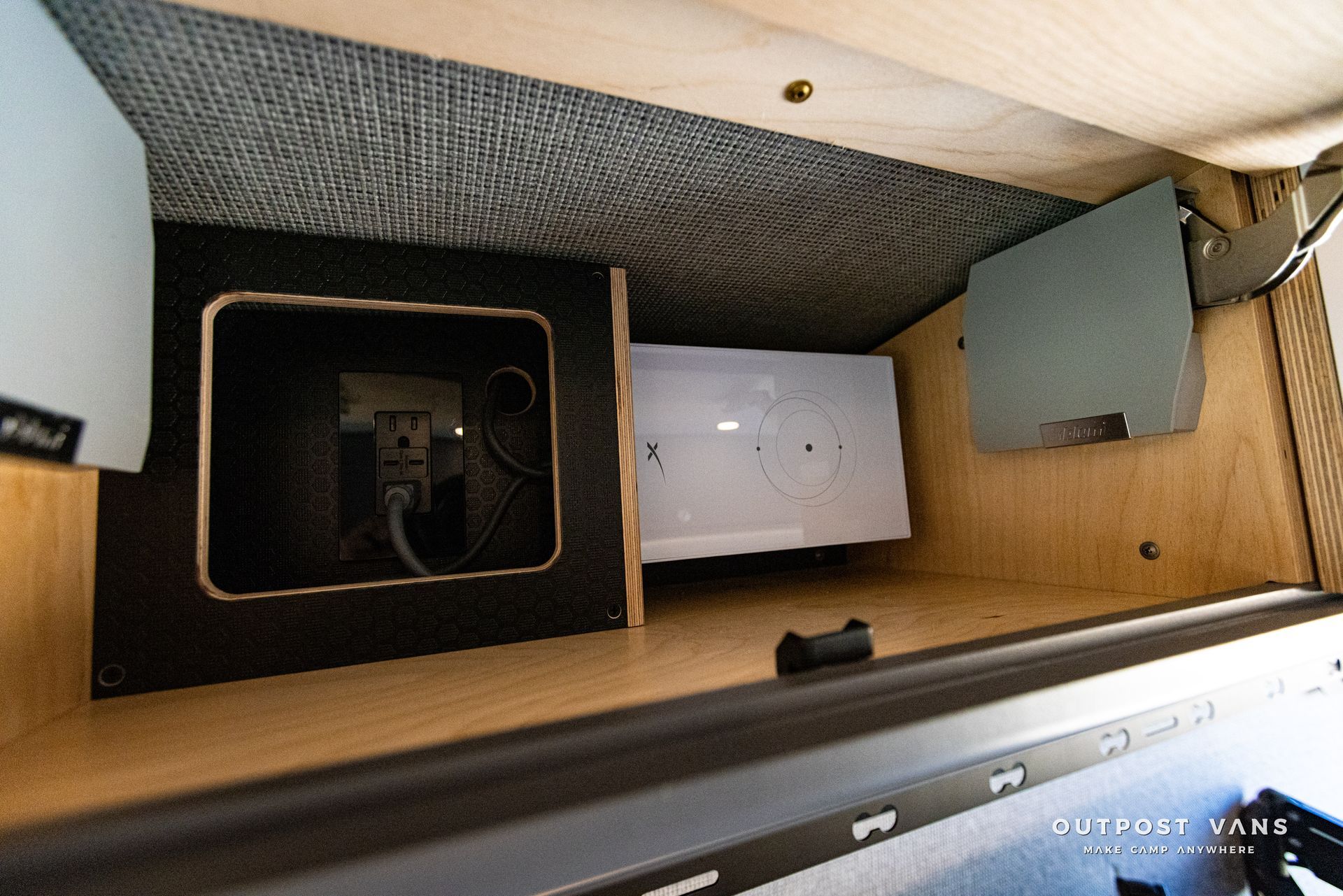 the inside of a camper van with a electrical outlet in the corner .