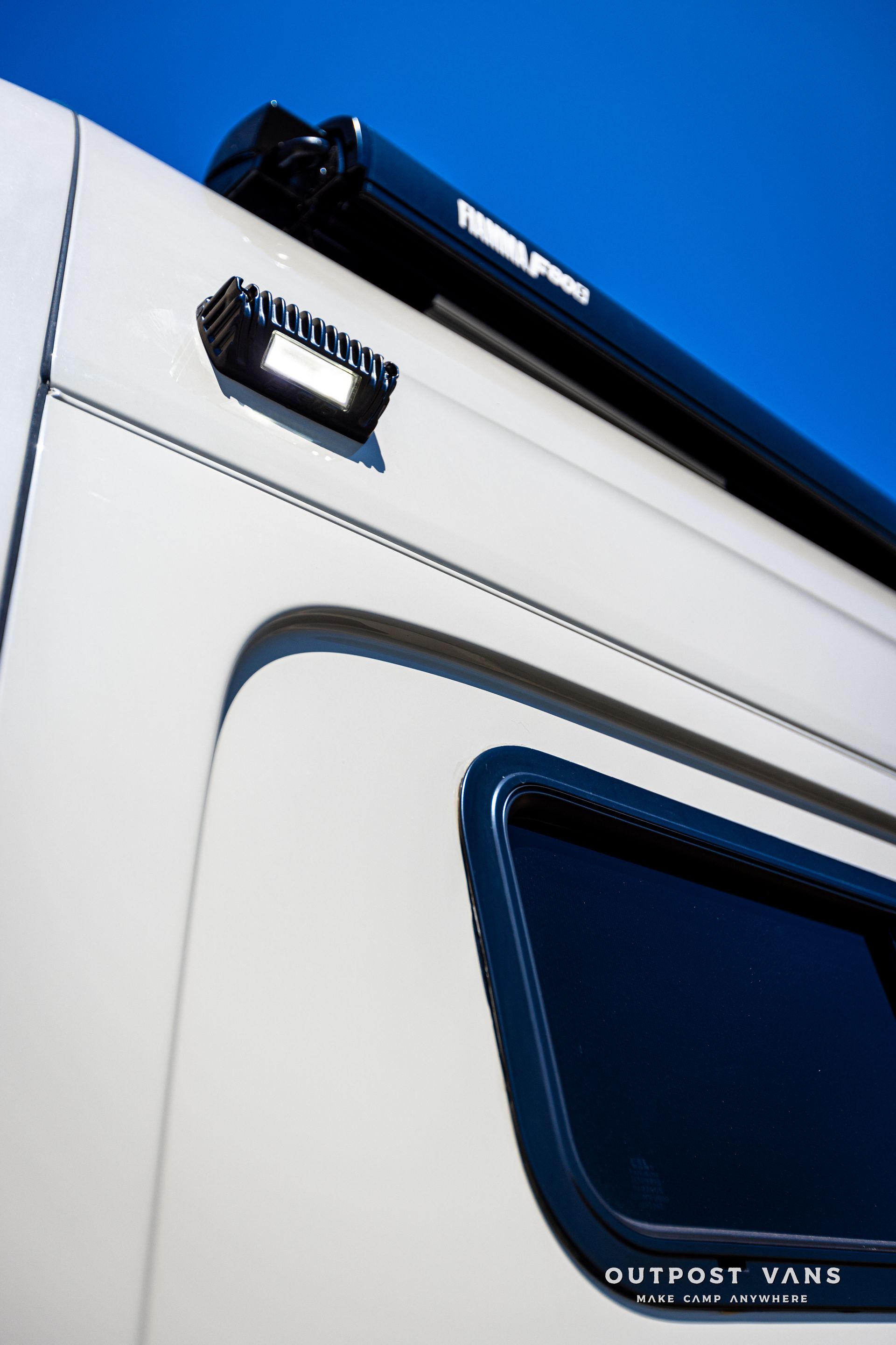 A white van with the word outpost vane on the side