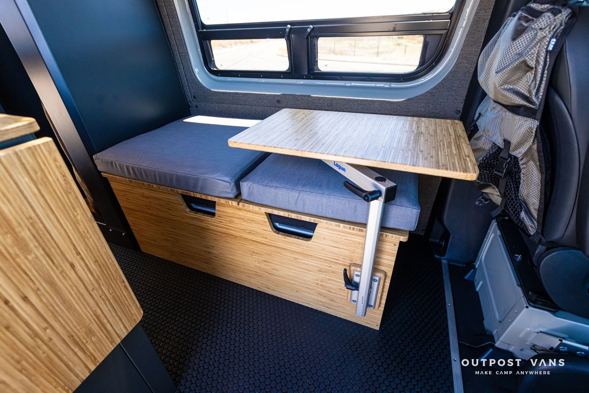A wooden table is sitting on a bench in a van.
