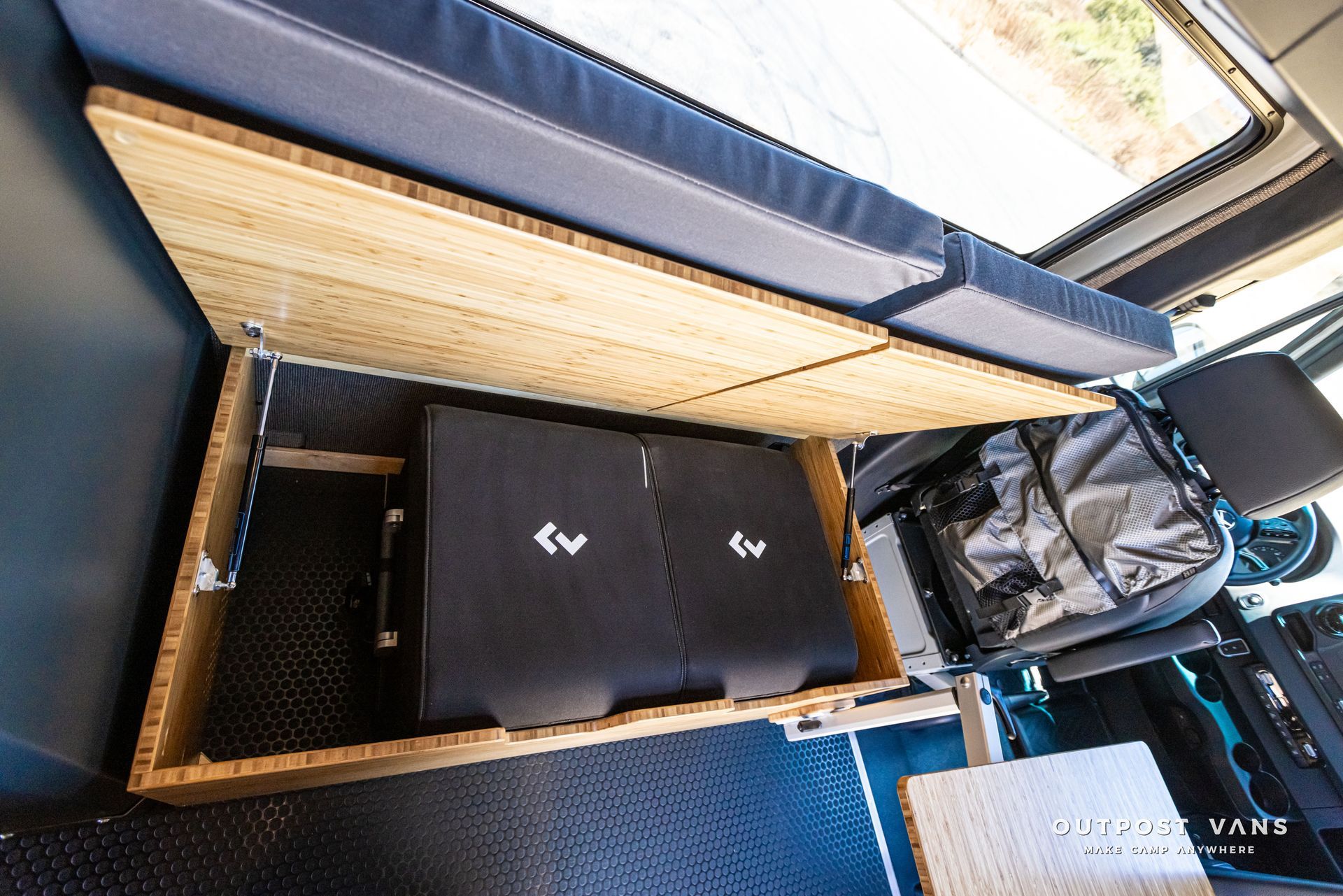 A car with a bed and a table underneath it.