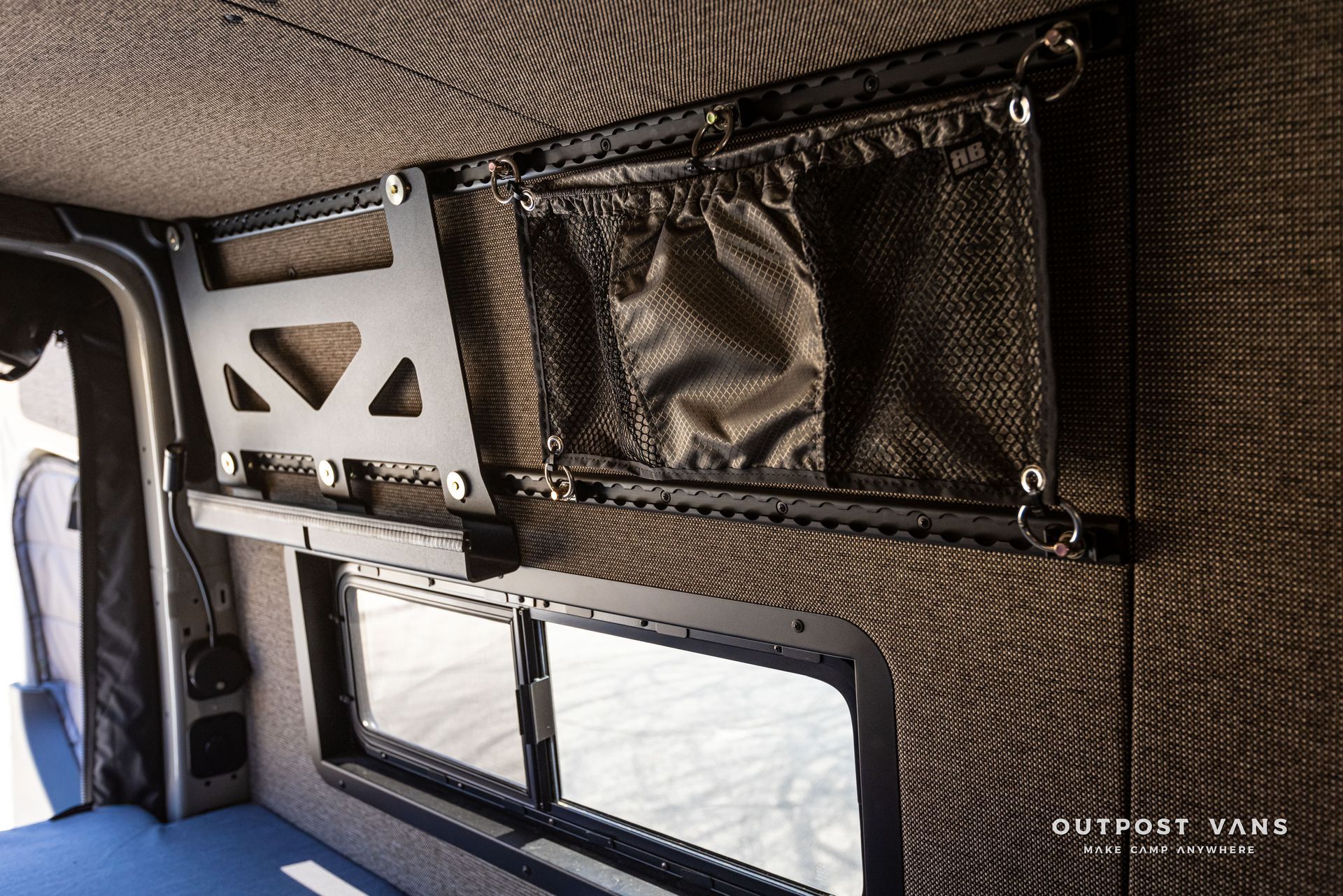 The inside of a van with a shelf and a window.