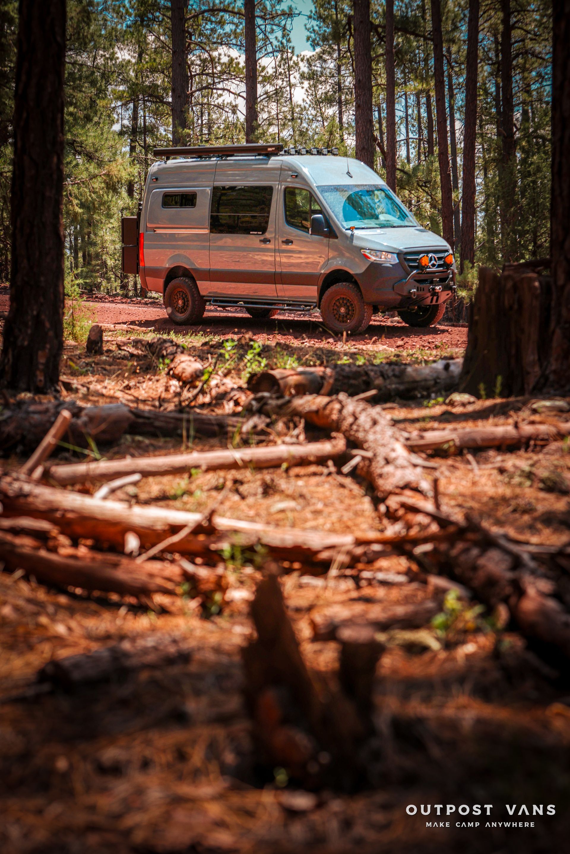 a van is parked in the middle of a forest .