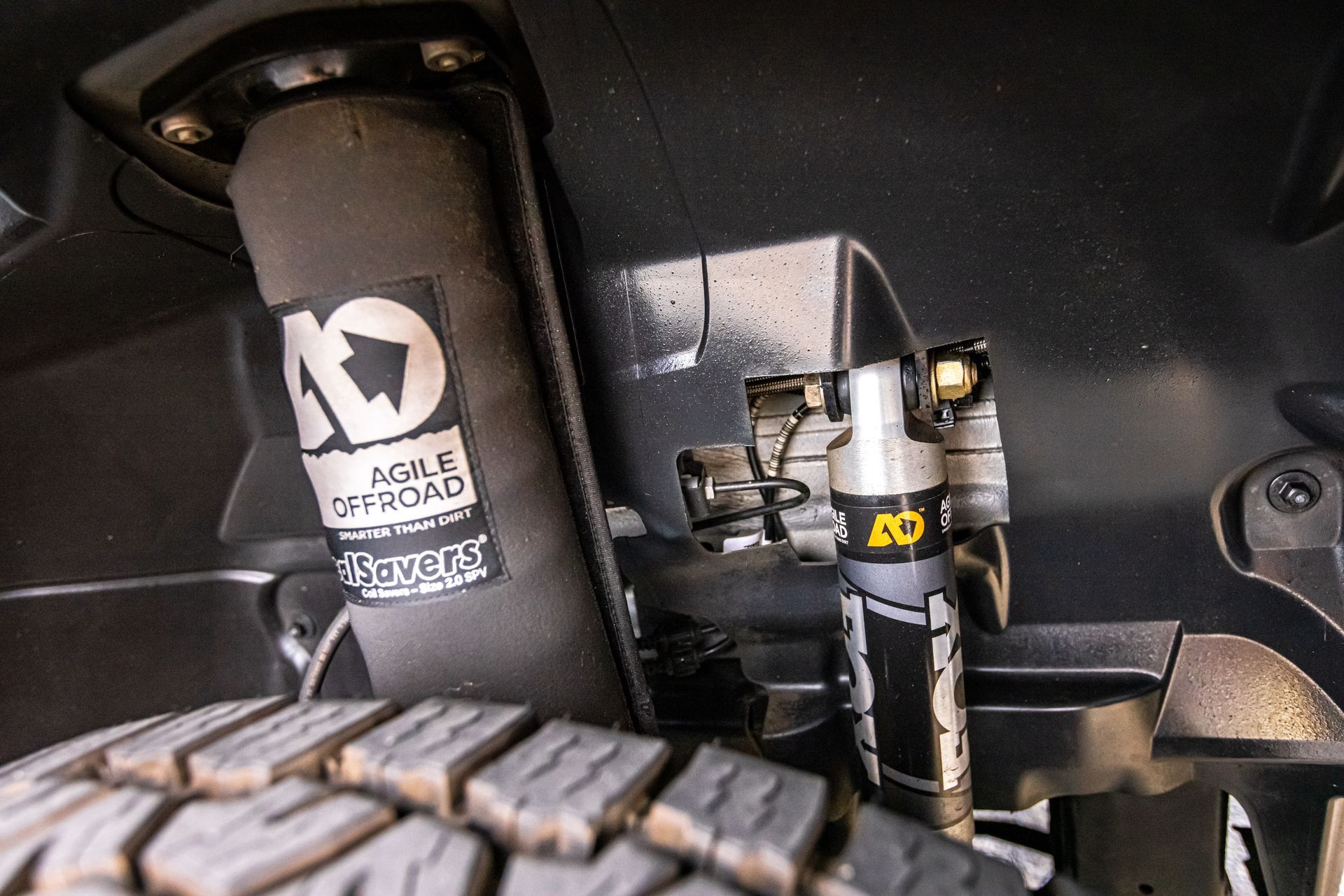 A close up of a shock absorber and a tire on a car.