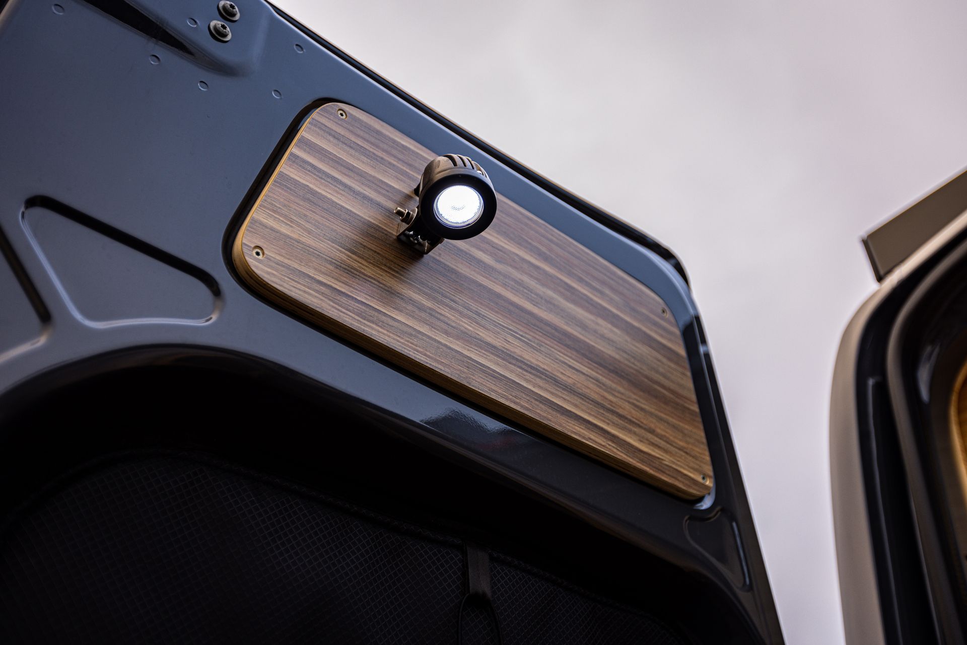 A close up of a wooden door with a light on it.