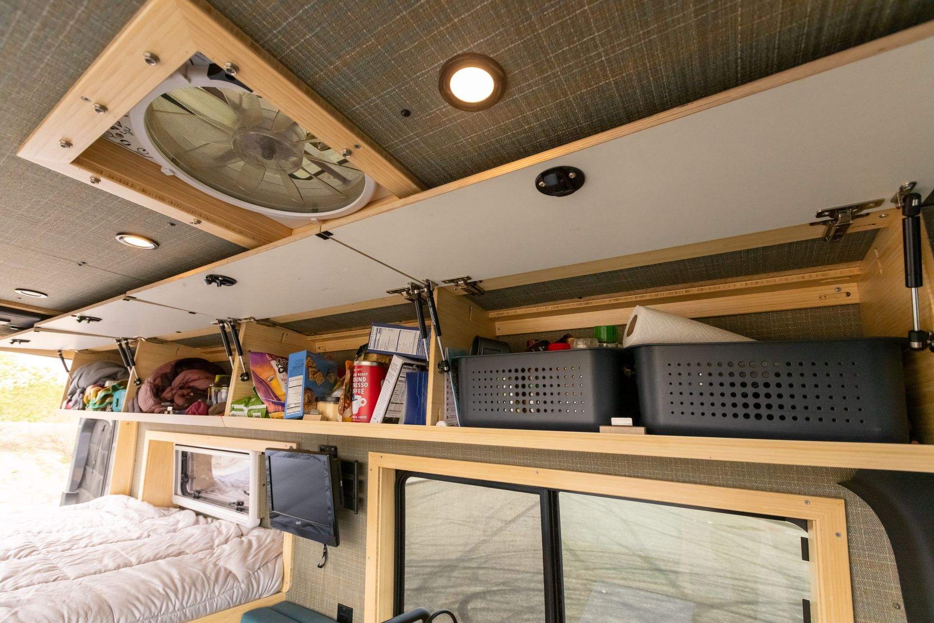 A ceiling fan is hanging from the ceiling of a camper van.