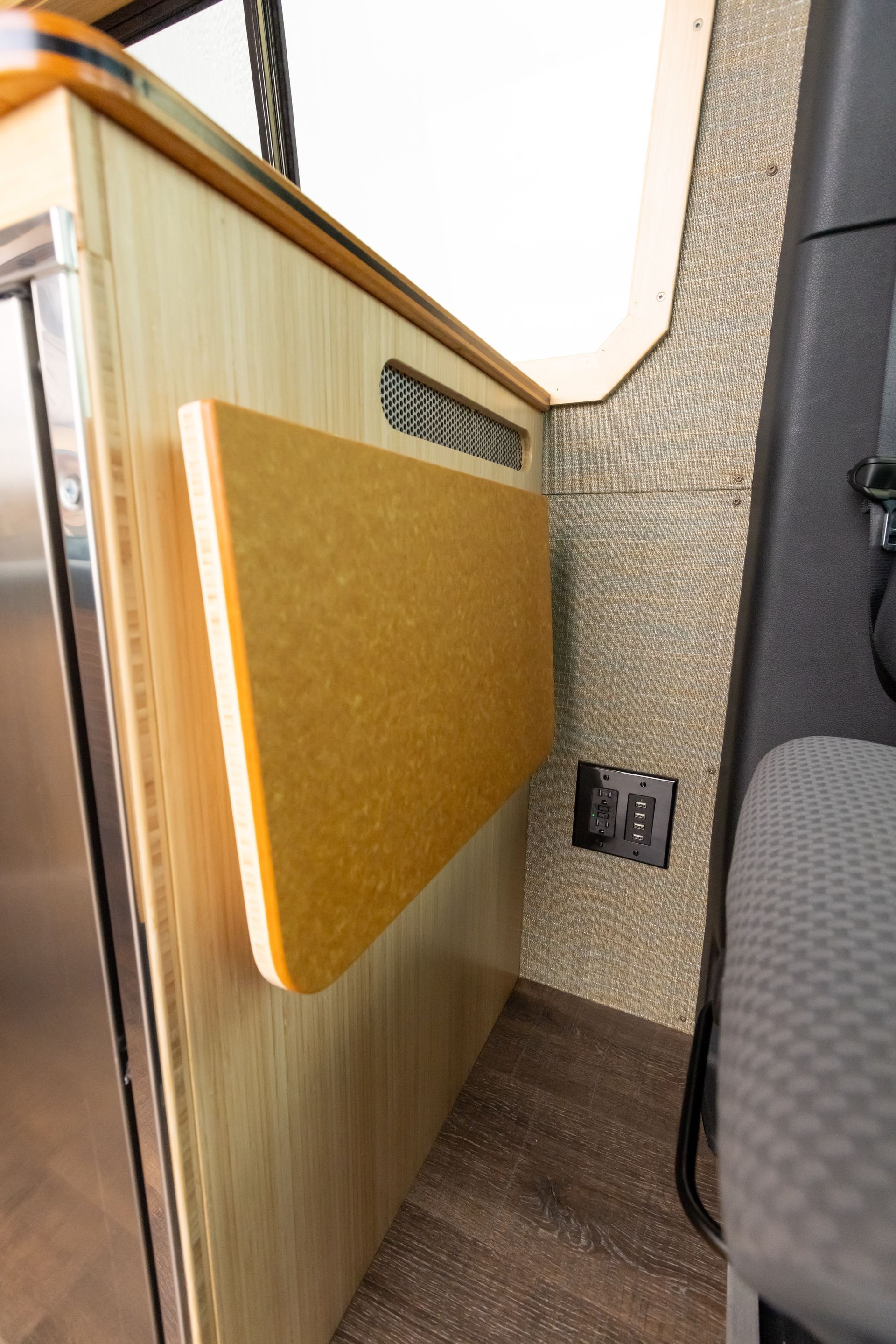 A folding table is attached to a wall in a van.