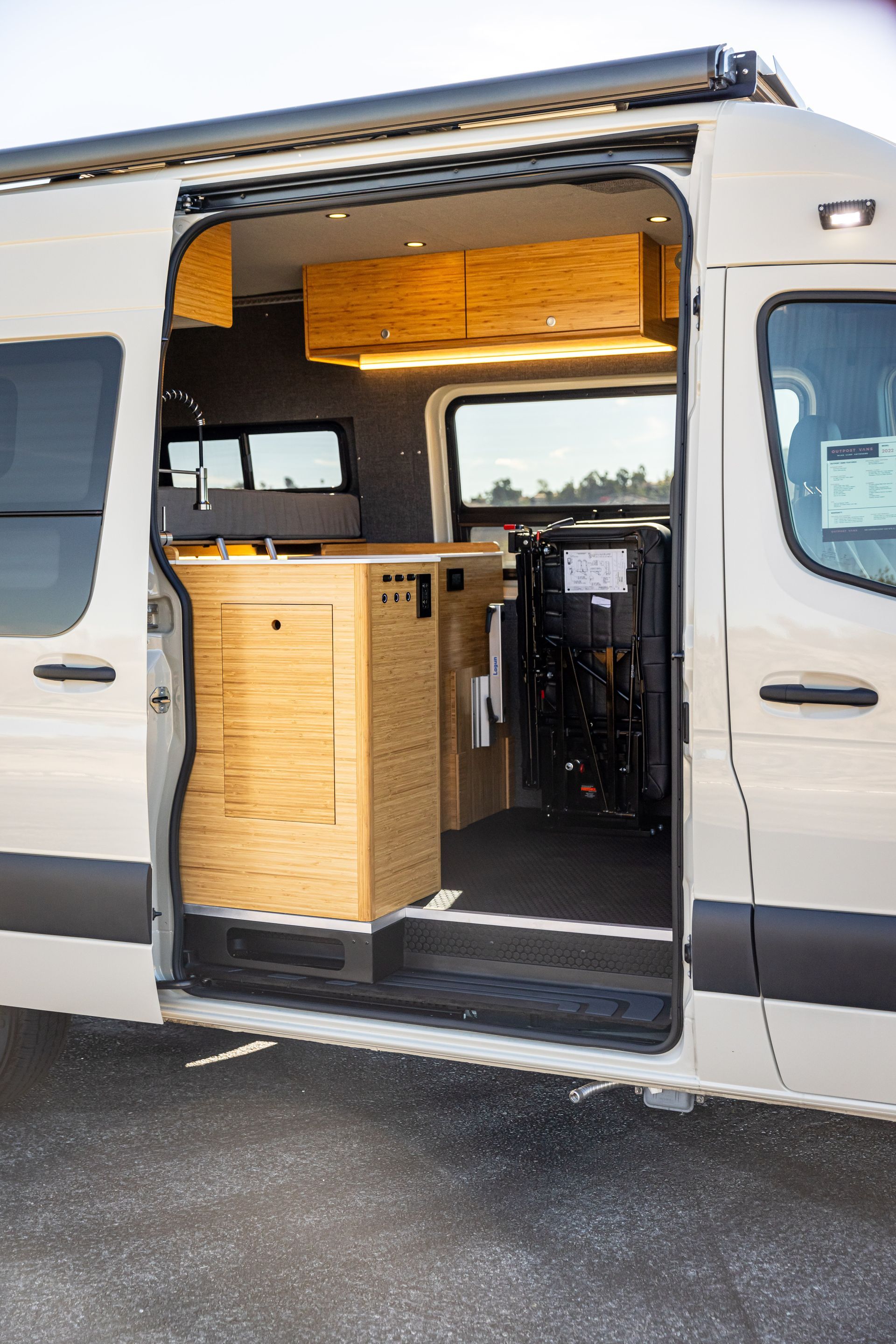 A white van with the door open is parked in a parking lot.