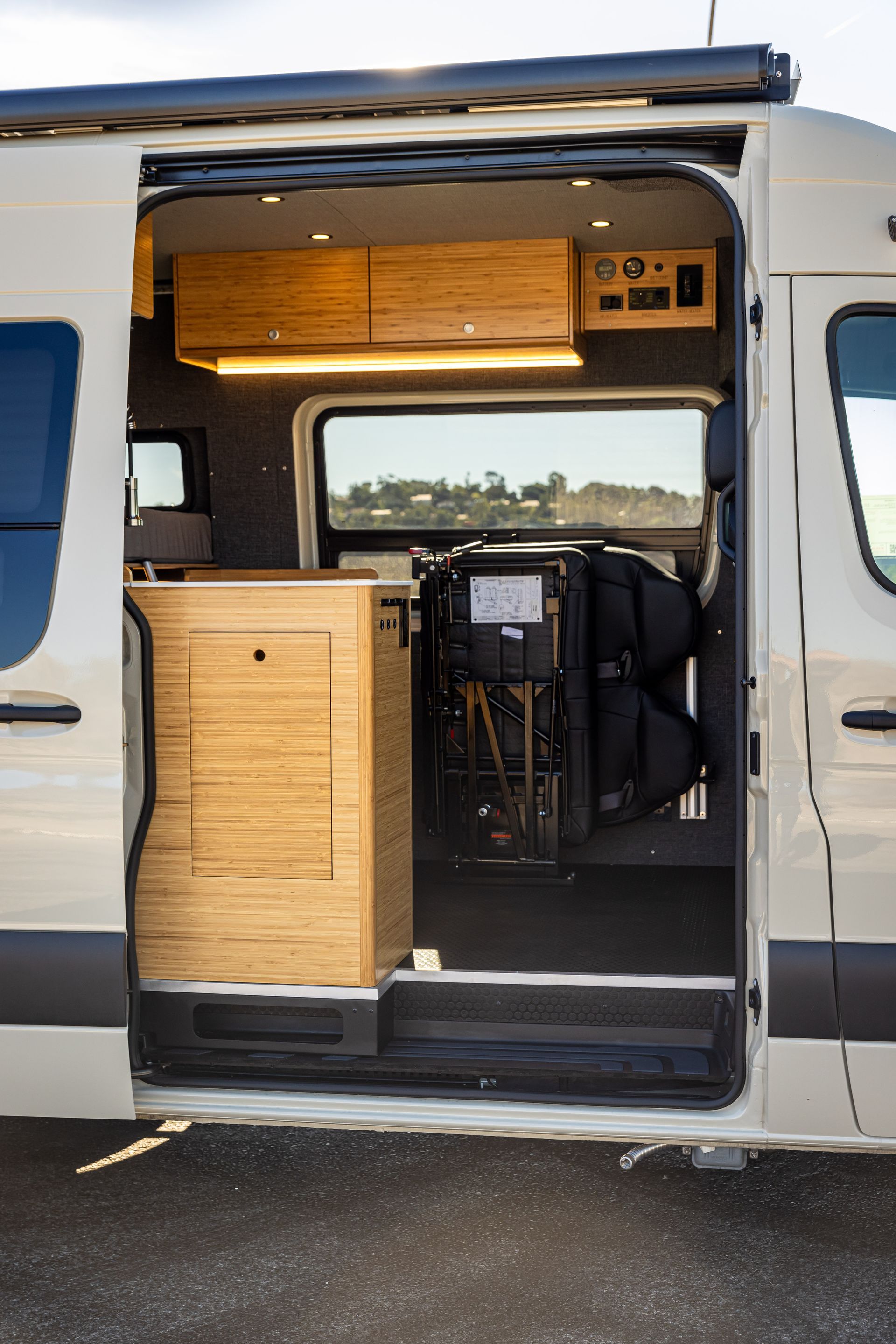 A white van with the door open and a chair in the back.
